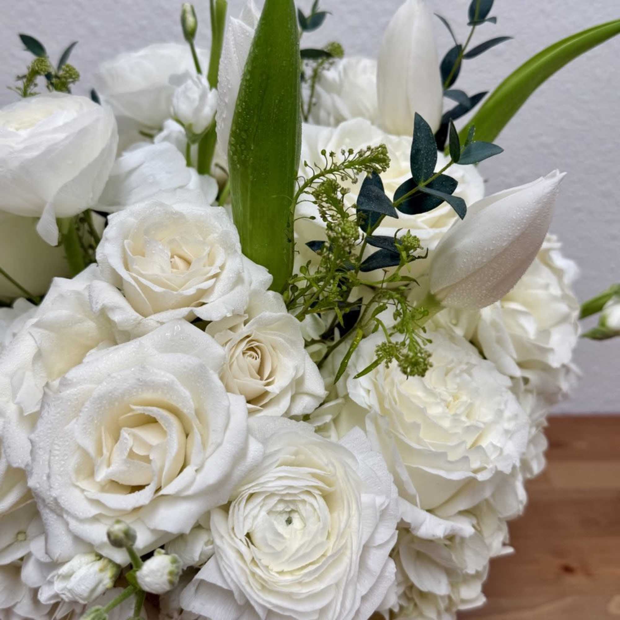 White rose and ranunculus bouquet with green accents