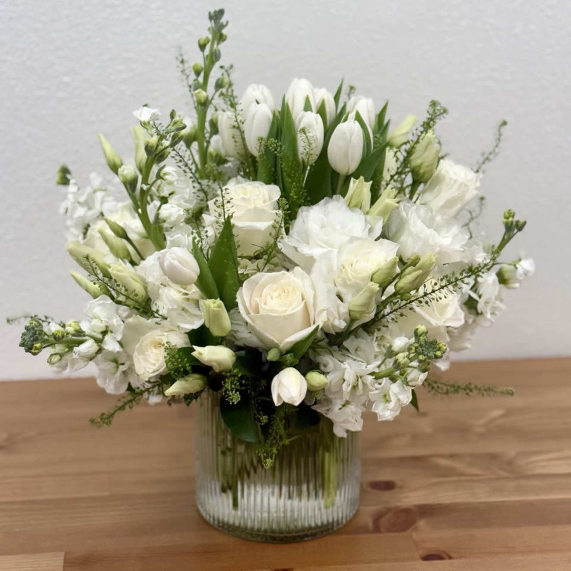 White floral arrangement in a ribbed glass vase