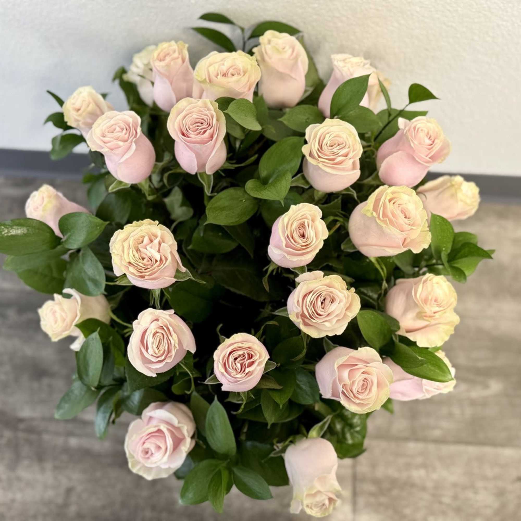 Bouquet of pale pink roses with glossy green foliage