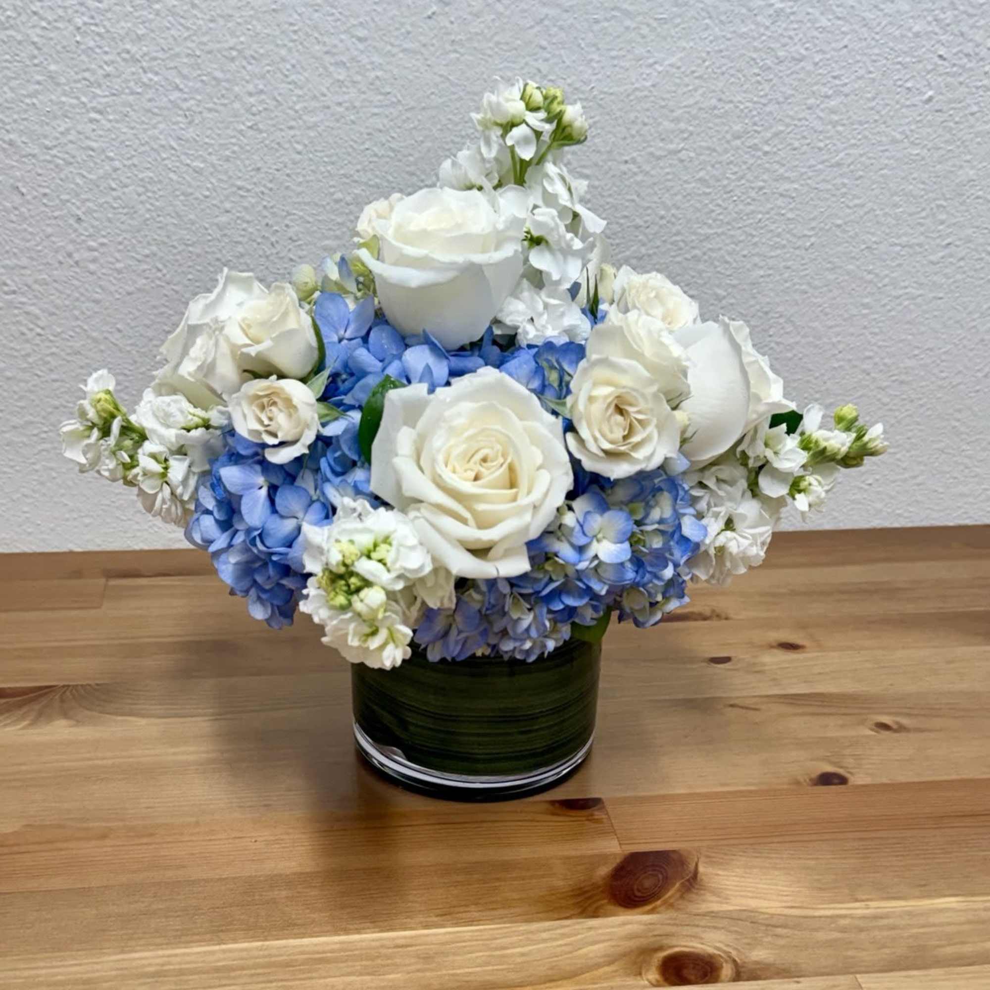 An elegant arrangement of white and blue flowers, artfully designed with premium