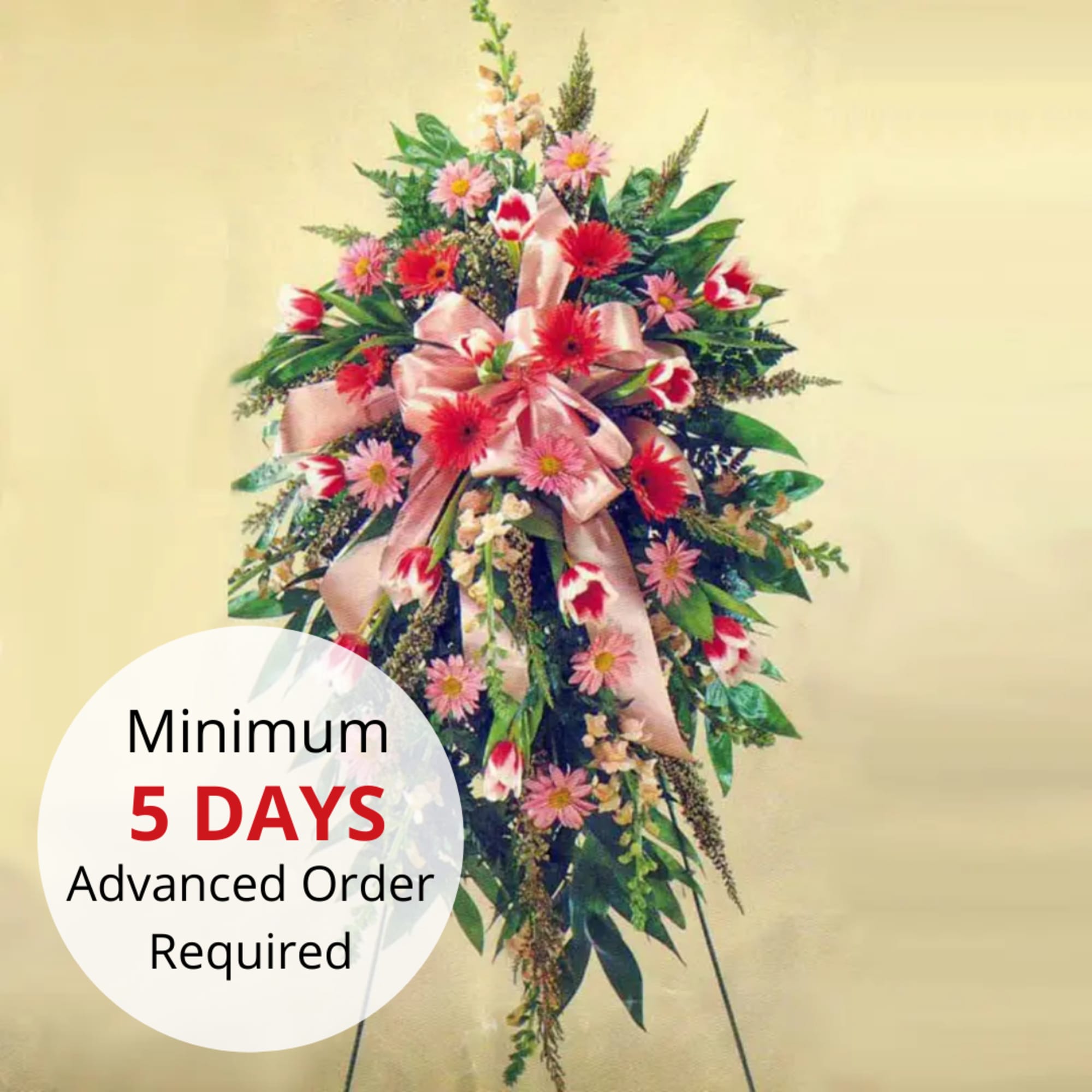 Tall pink and red standing spray with a large bow on a metal easel