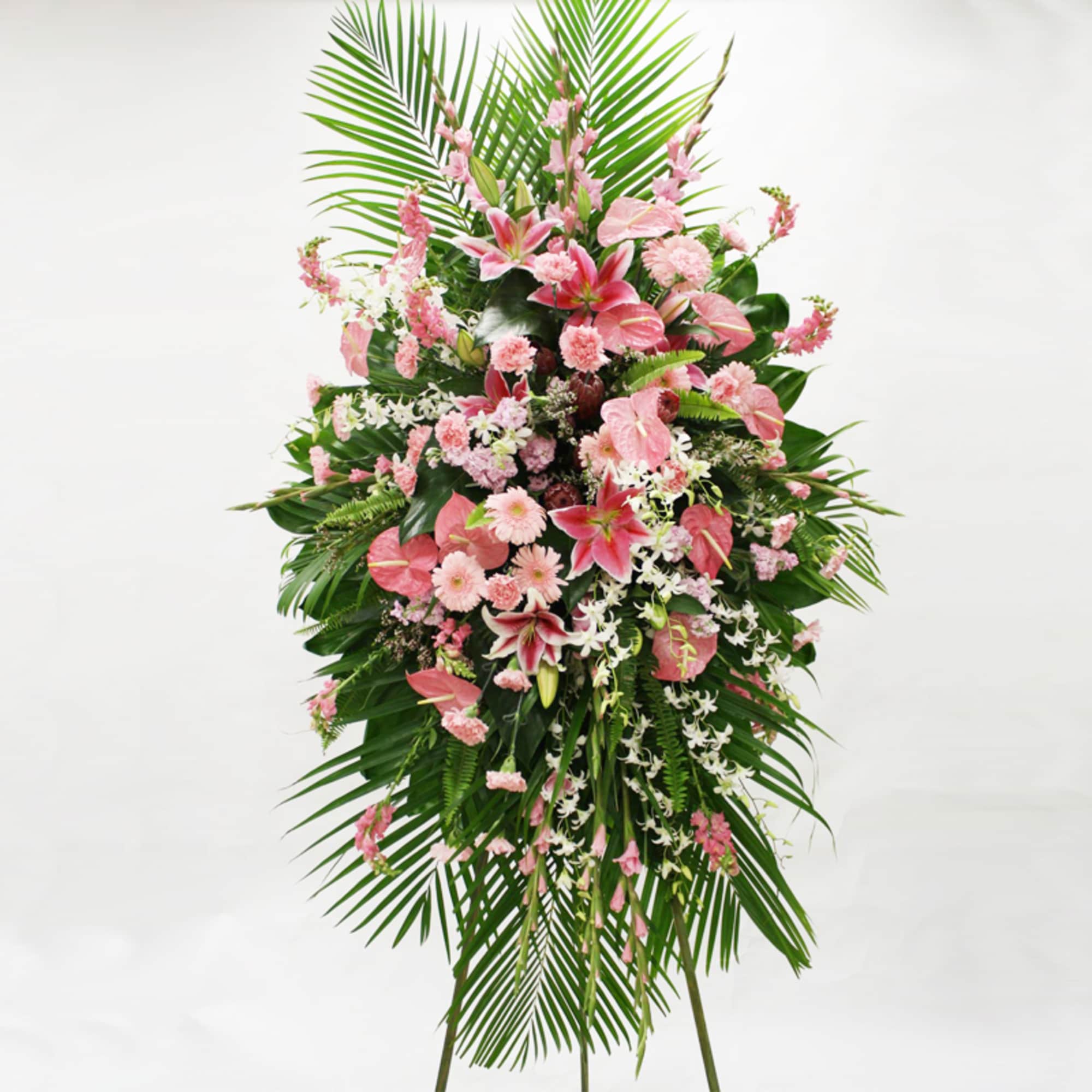 Tall pink and white standing spray with lilies and tropical blooms on a metal easel