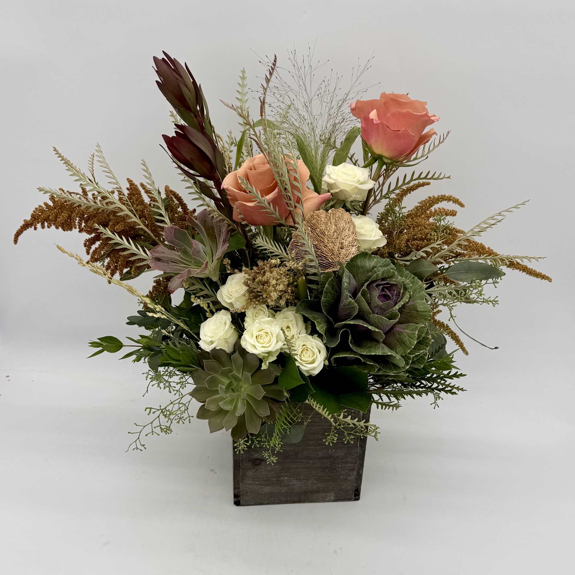 Mixed bouquet with roses and succulents in a wooden box
