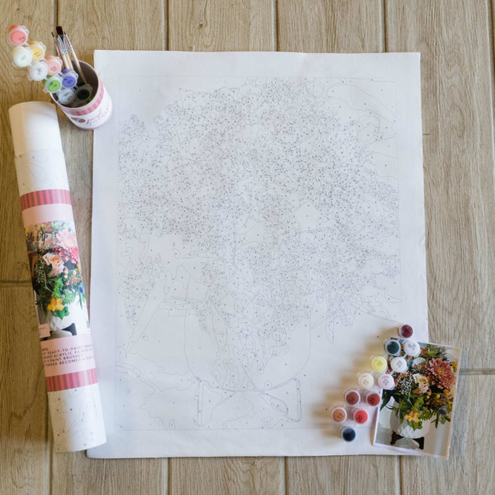 Paint-by-number floral kit with canvas, paint pots, brushes, and reference card