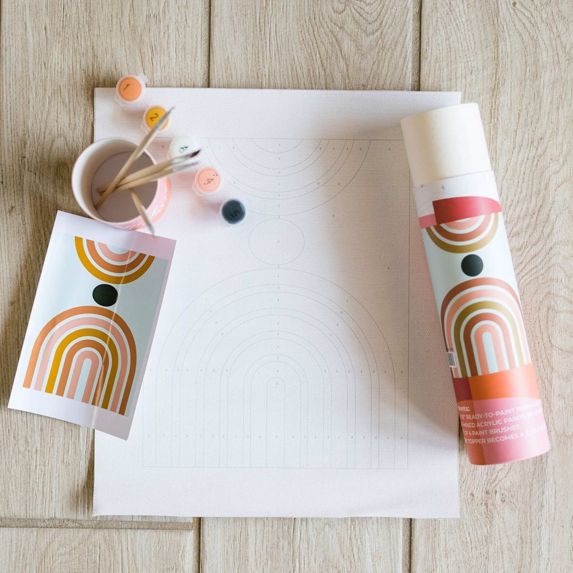 Paint-by-number kit with brushes, paint pots, and rainbow print sheets