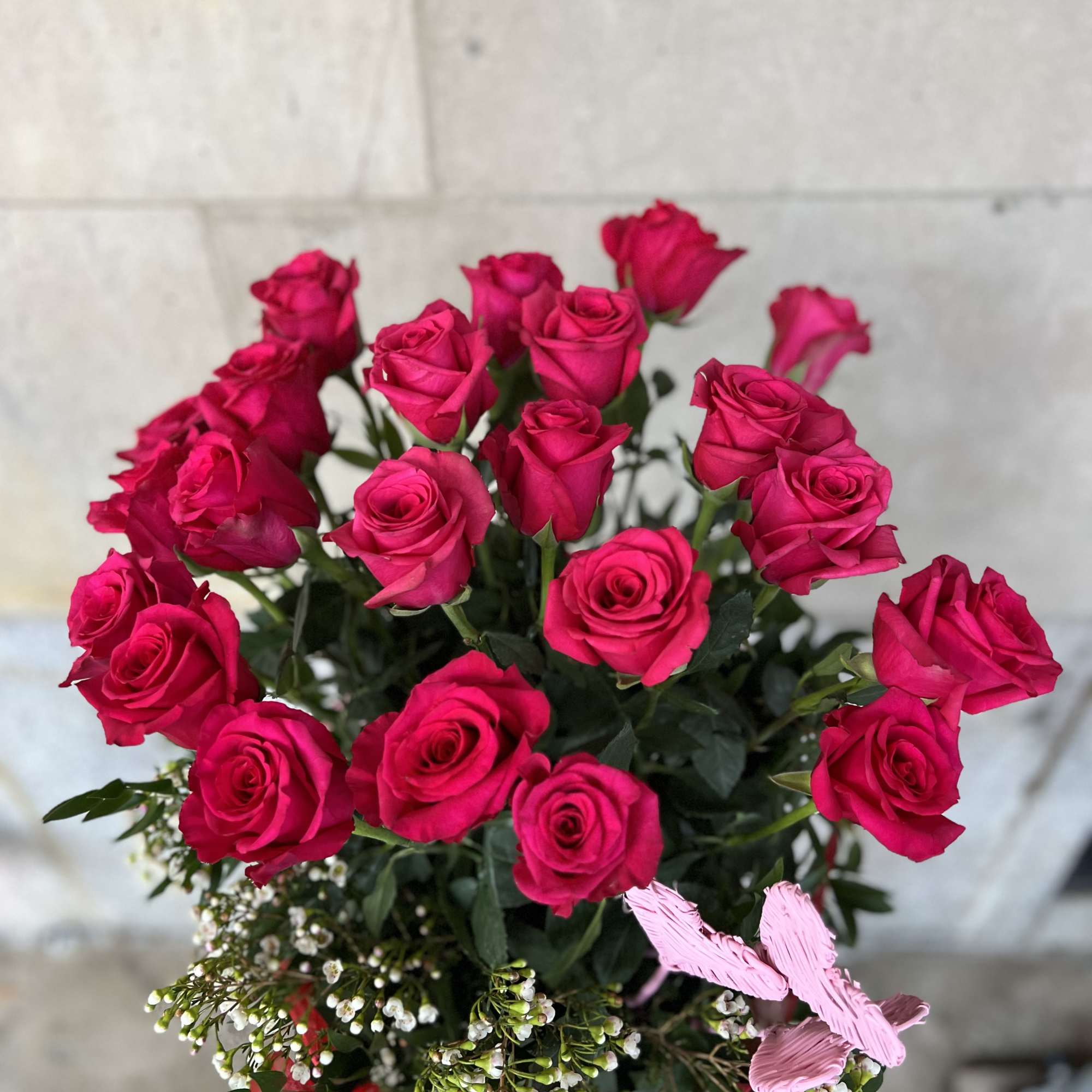 Bouquet of hot pink roses with small white filler flowers
