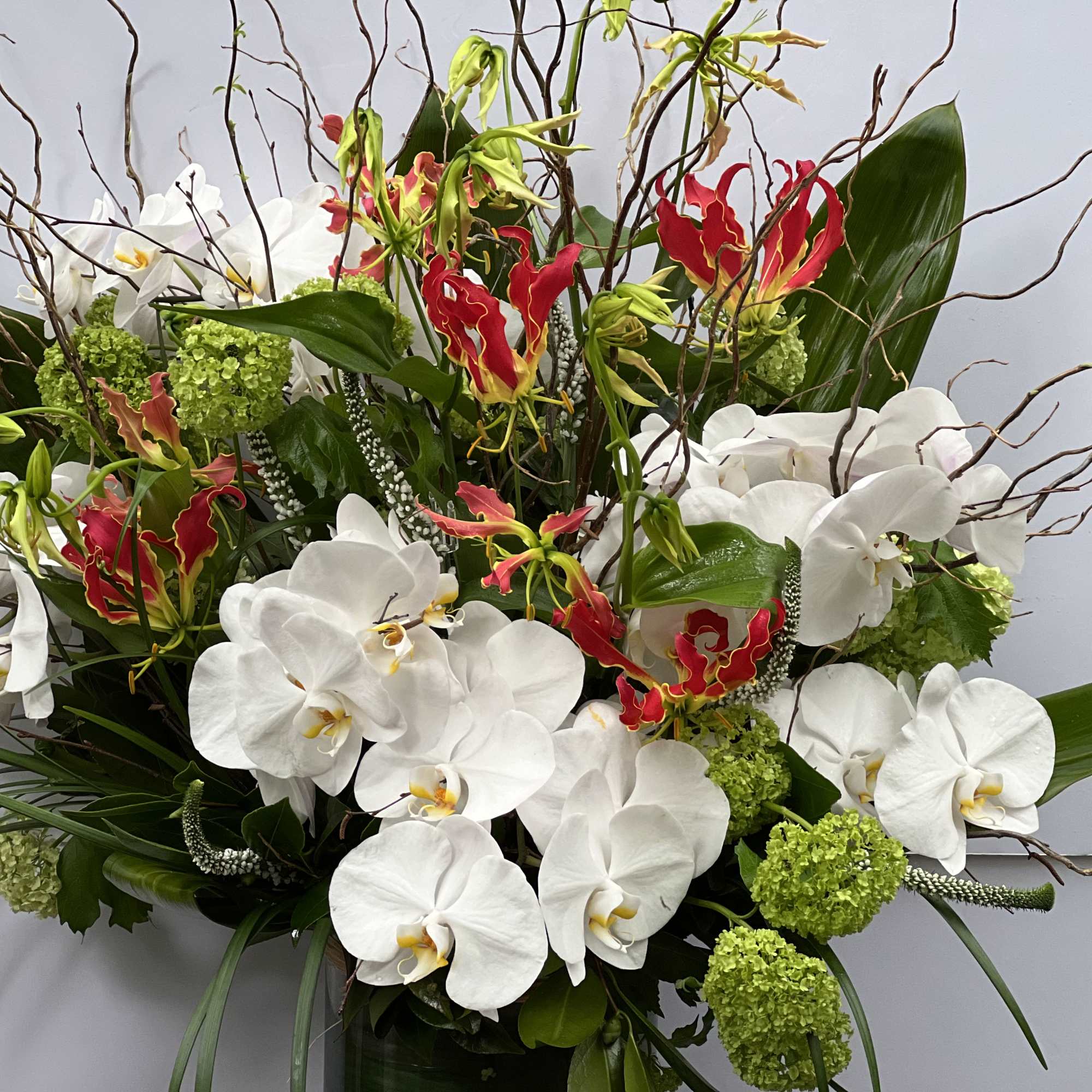 CYLINDRICAL VASE WITH JAPANESE GLORIOSA, WHITE PHALAENOPSIS ORCHIDS, VIBURNUM, THAI LEAF, AND, photo 5 of 10