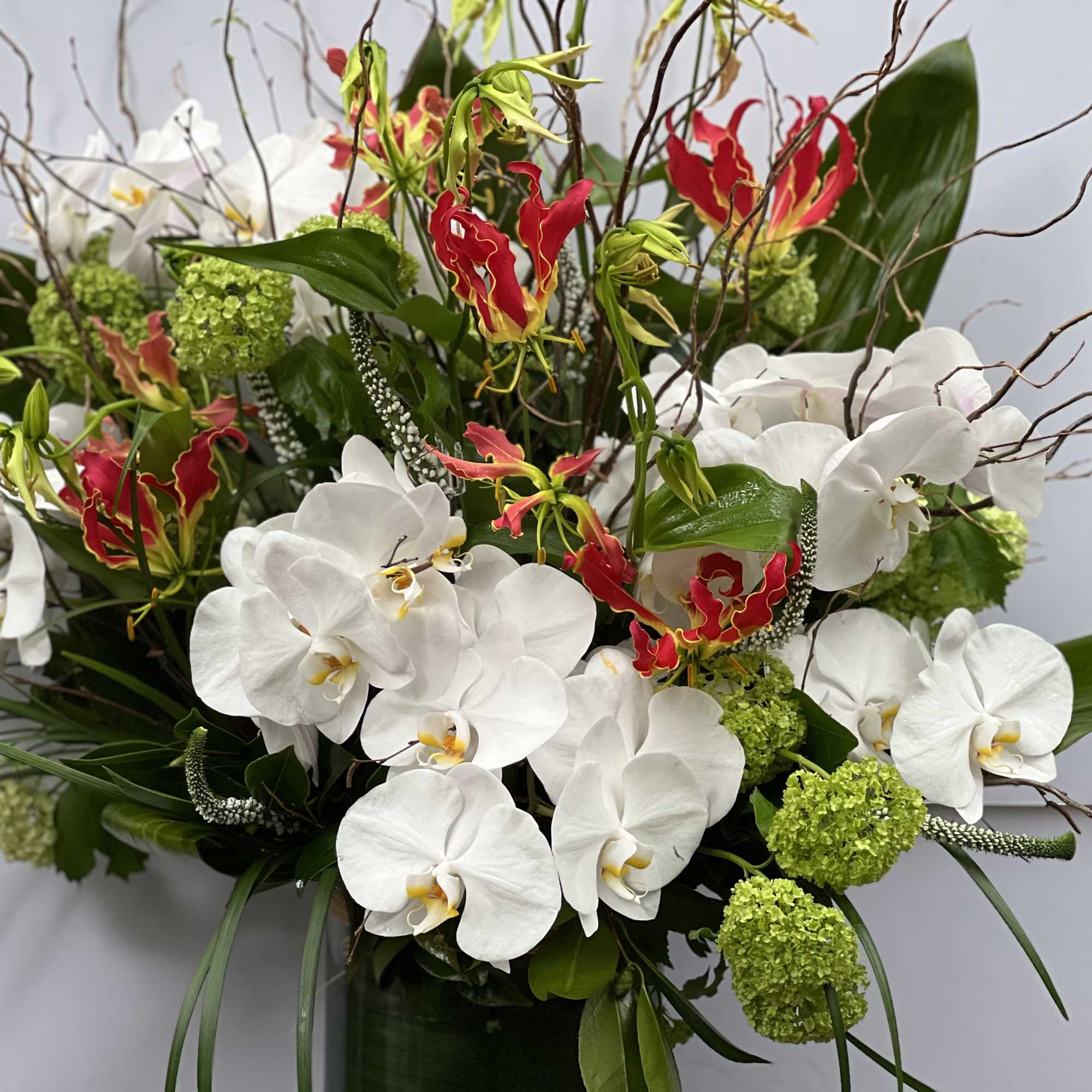 CYLINDRICAL VASE WITH JAPANESE GLORIOSA, WHITE PHALAENOPSIS ORCHIDS, VIBURNUM, THAI LEAF, AND, photo 7 of 10