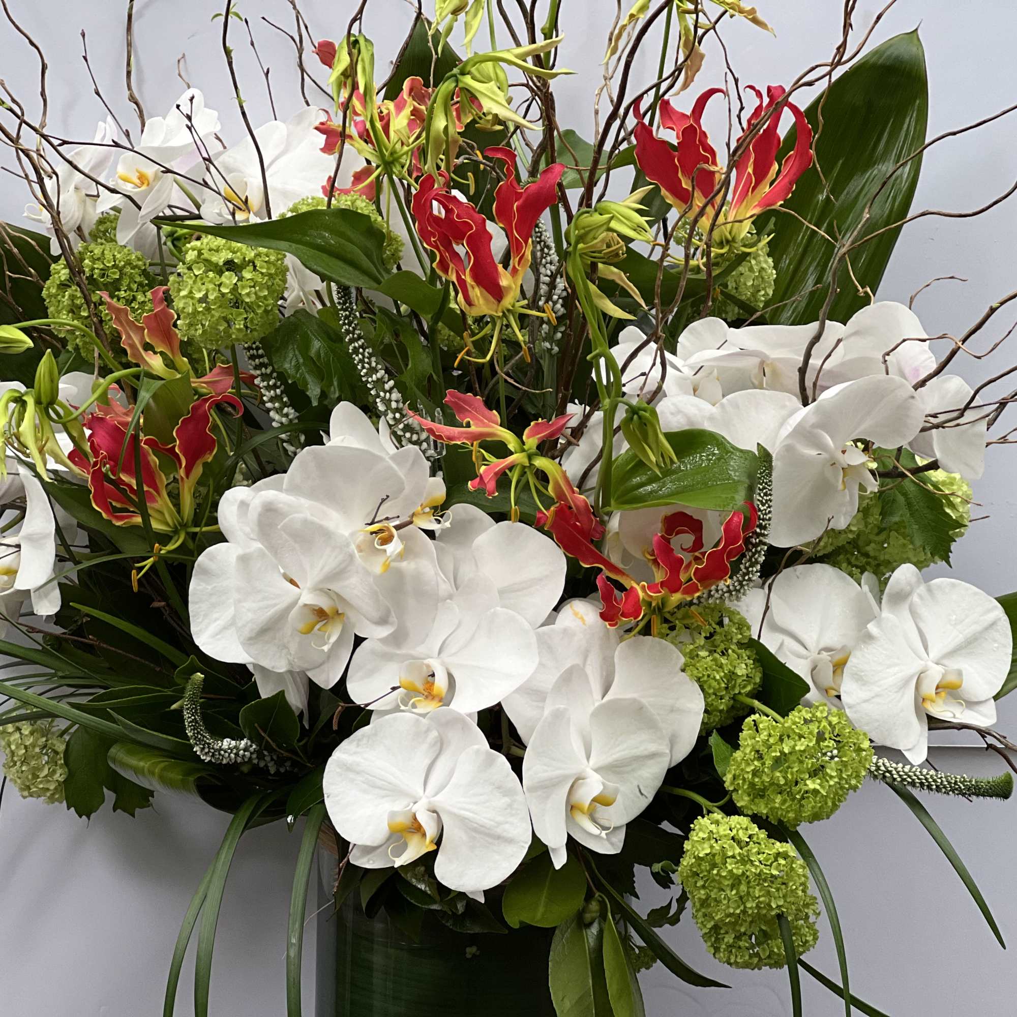 CYLINDRICAL VASE WITH JAPANESE GLORIOSA, WHITE PHALAENOPSIS ORCHIDS, VIBURNUM, THAI LEAF, AND, photo 8 of 10