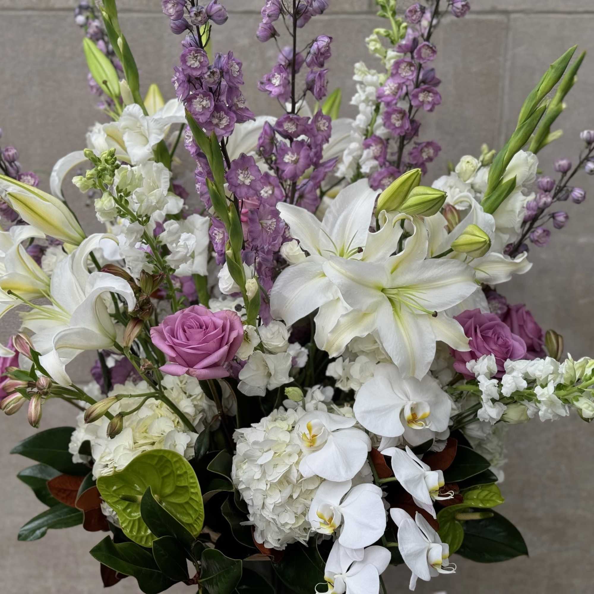 Tall and lush display of flowers features, white hydrangeas, hybrid delphinium, lavender, photo 3 of 6
