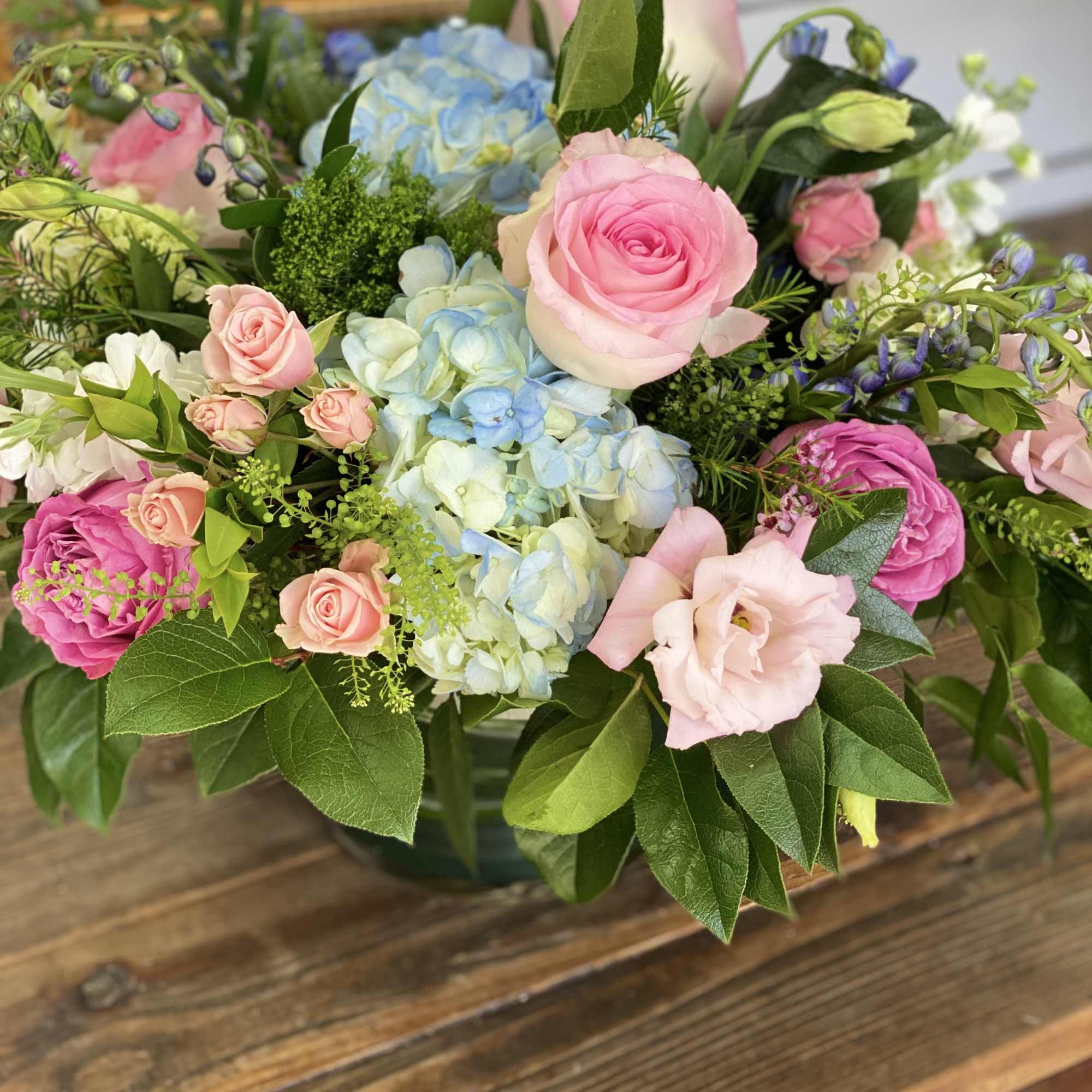 Mixed bouquet of pink roses and blue hydrangeas in a vase