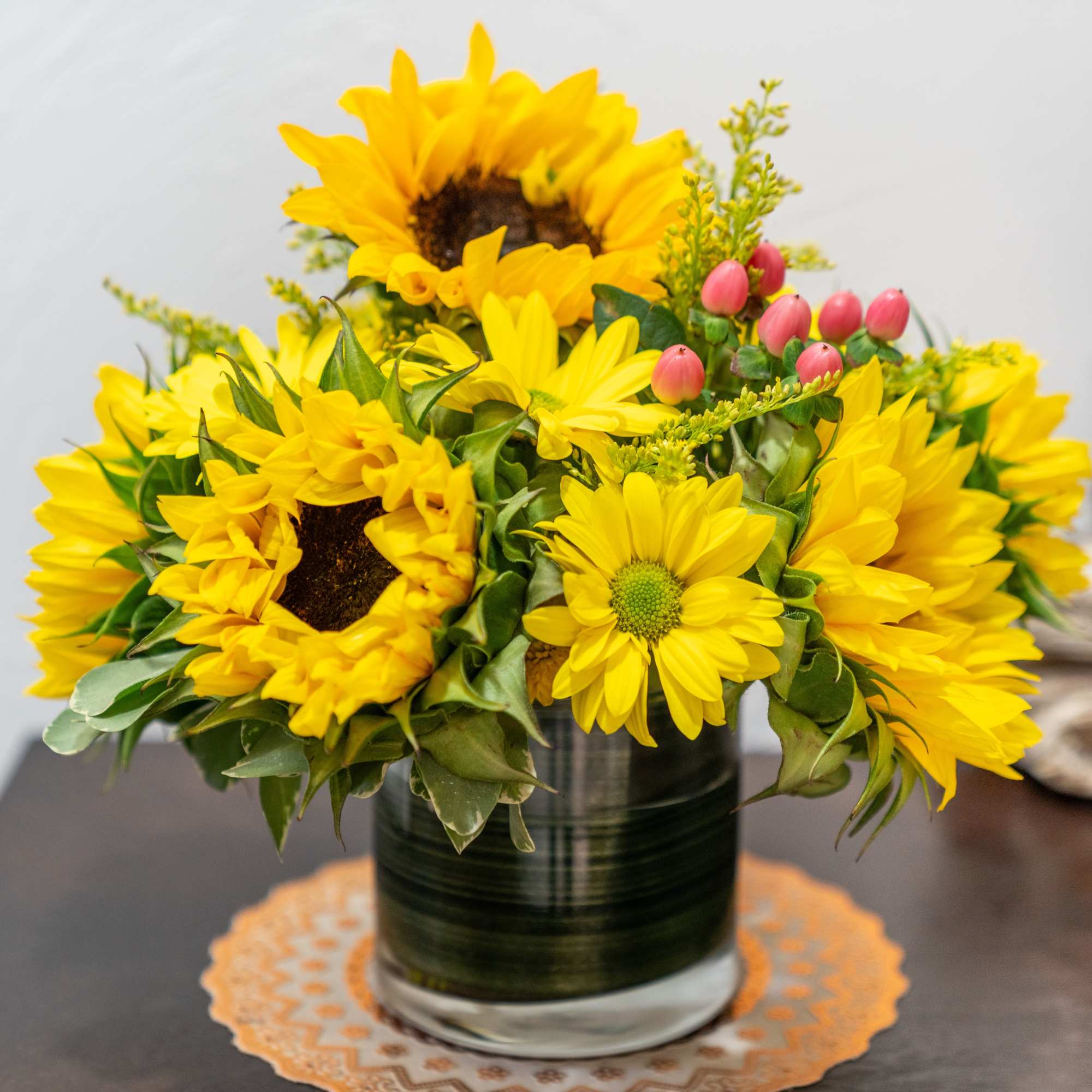 This delightful bouquet features brilliant sunflowers complemented by fresh greenery and cheerful