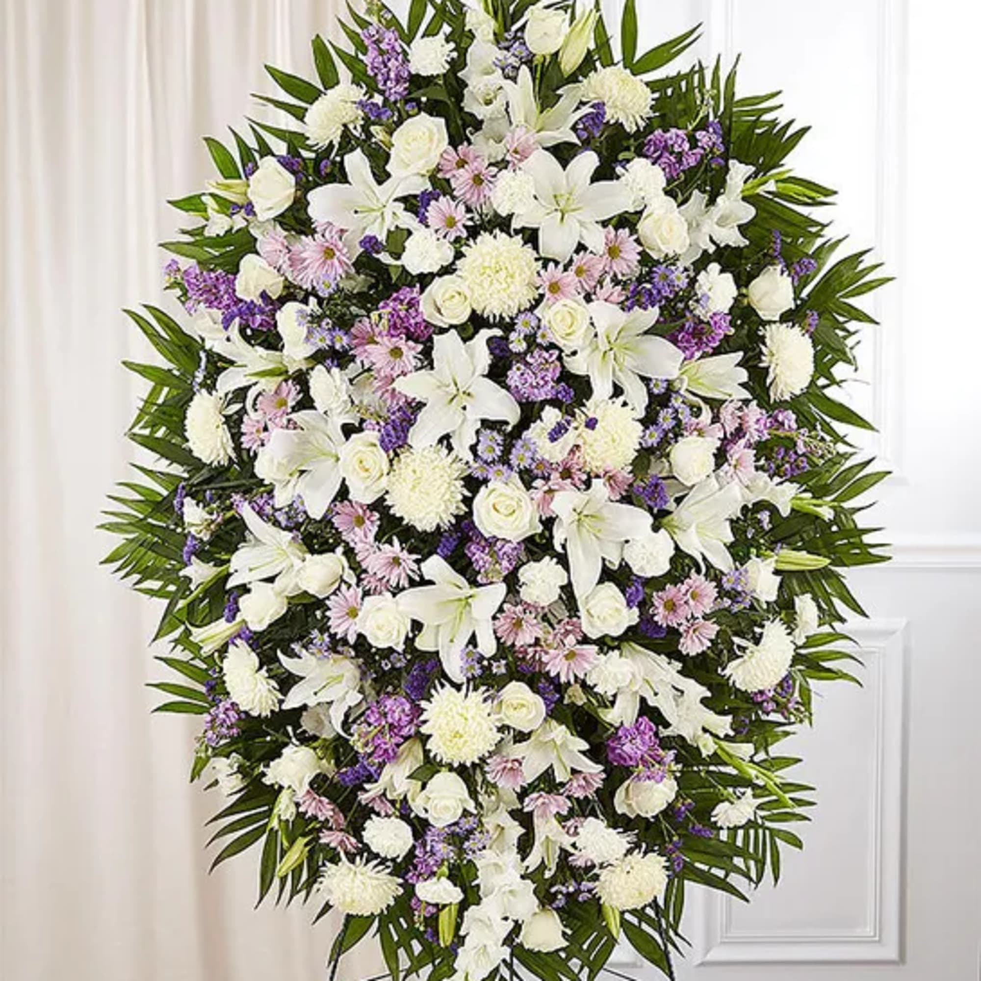 Large standing spray of white and lavender flowers on an easel