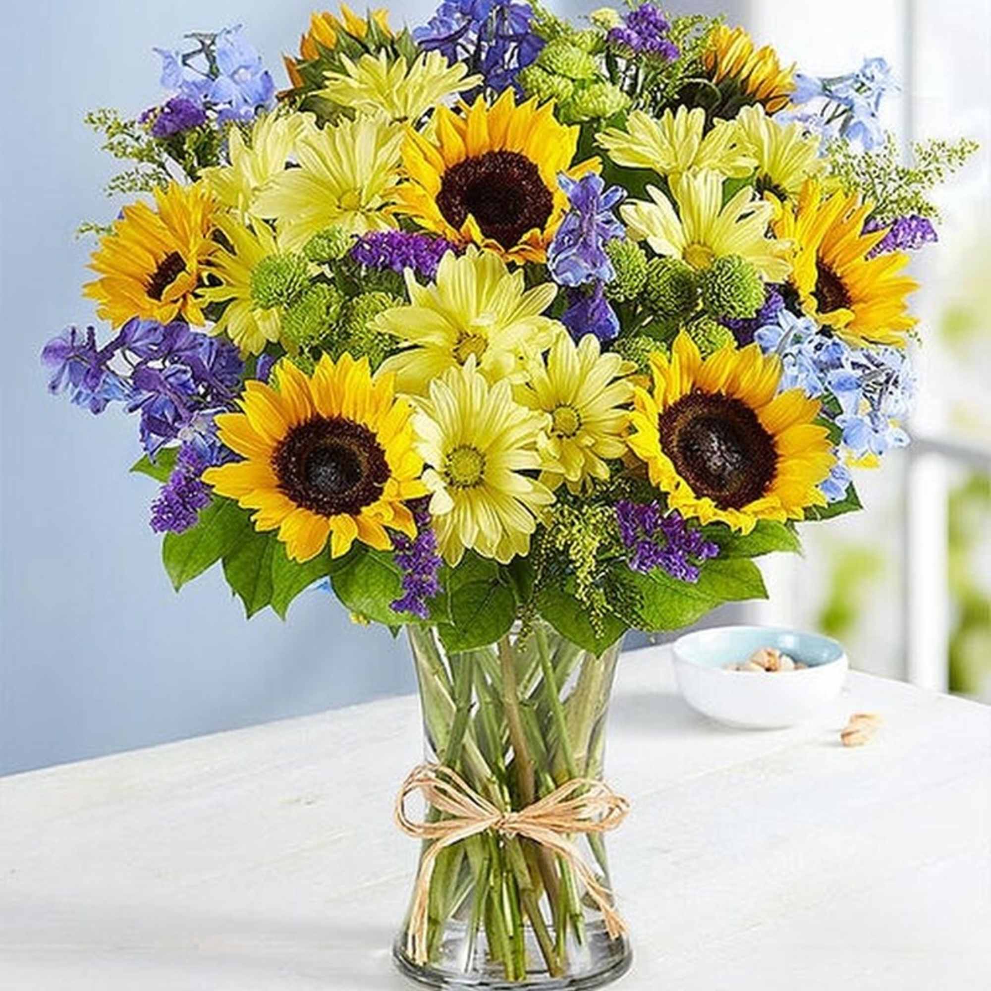Bouquet of sunflowers, yellow daisies, and purple flowers in a glass vase, photo 2 of 2