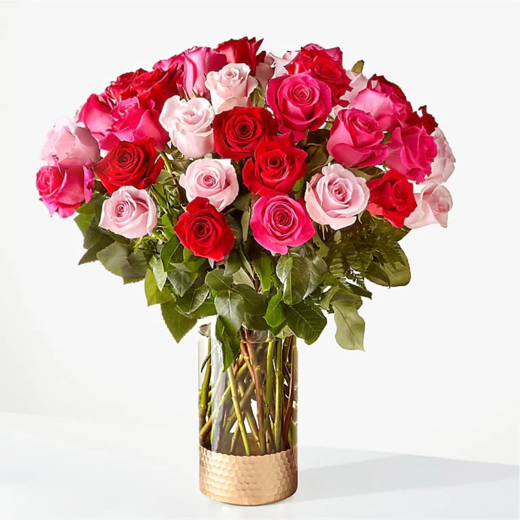 Bouquet of red, pink, and pale pink roses in a glass vase