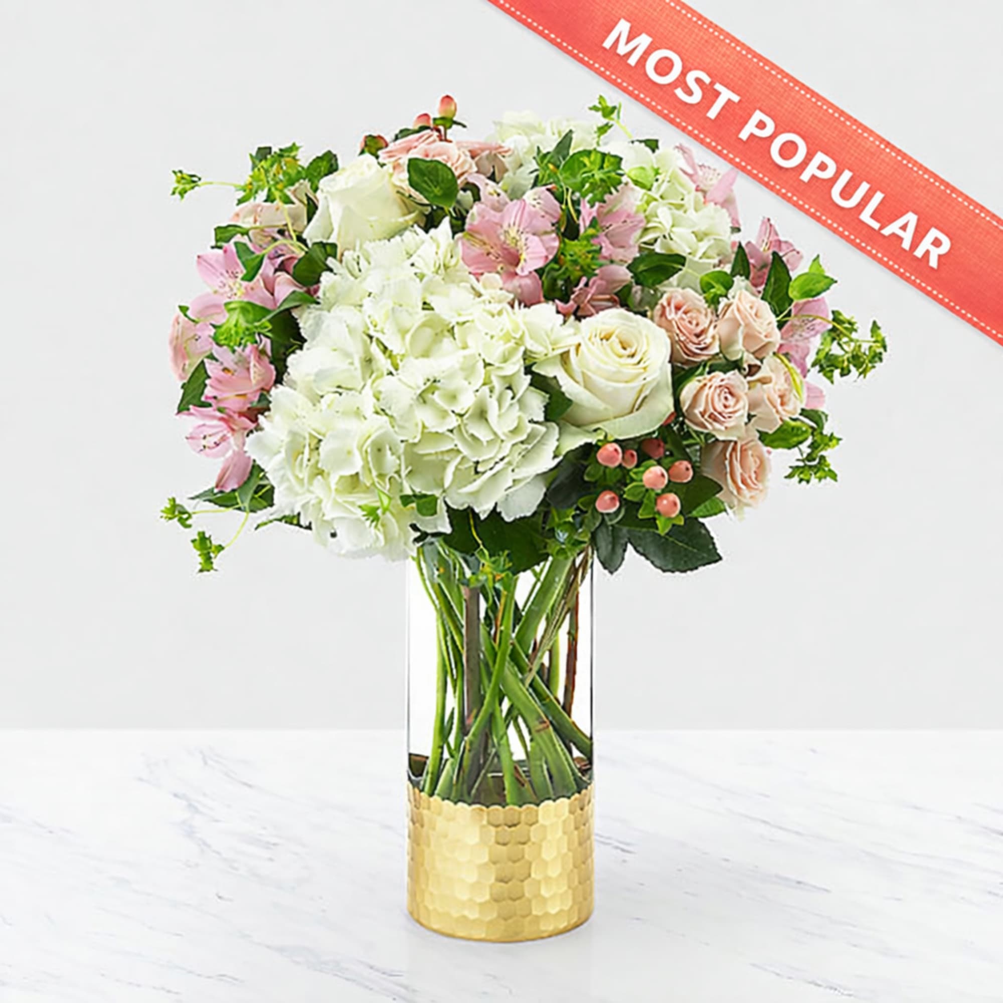Bouquet of white and pink flowers in a tall glass vase