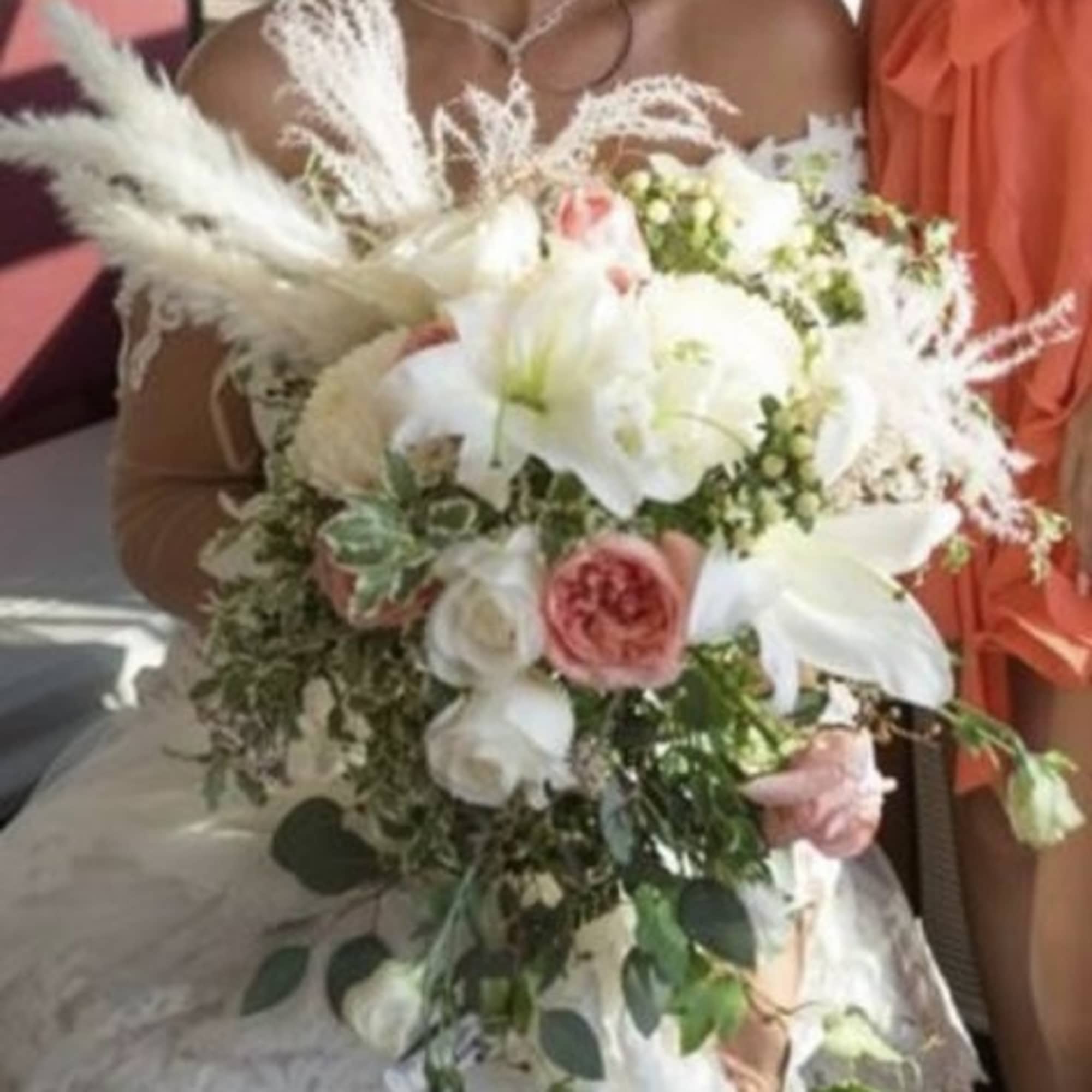 Bride holding a bouquet of white lilies and pink roses