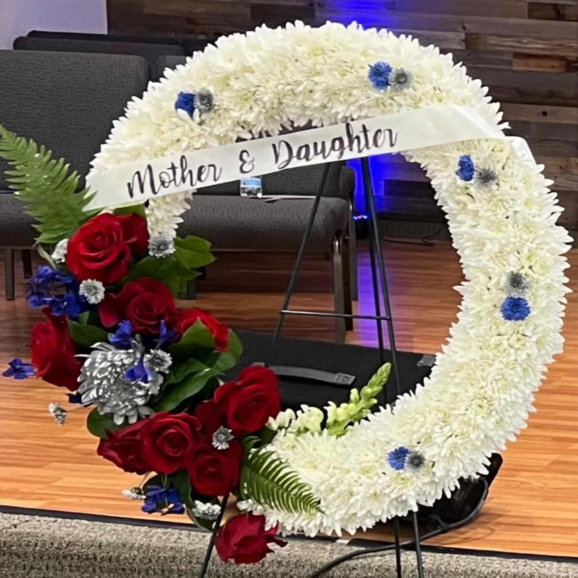 Heart-shaped floral tribute with white chrysanthemums and red roses