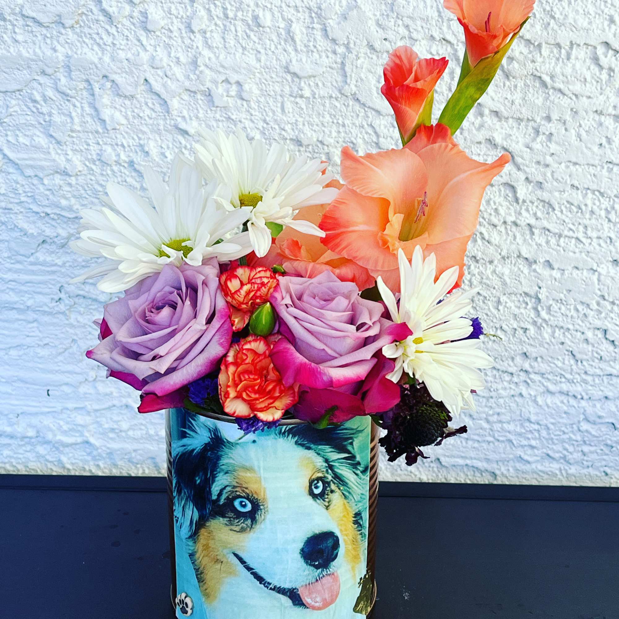 Colorful bouquet in a decorated tin with a dog illustration