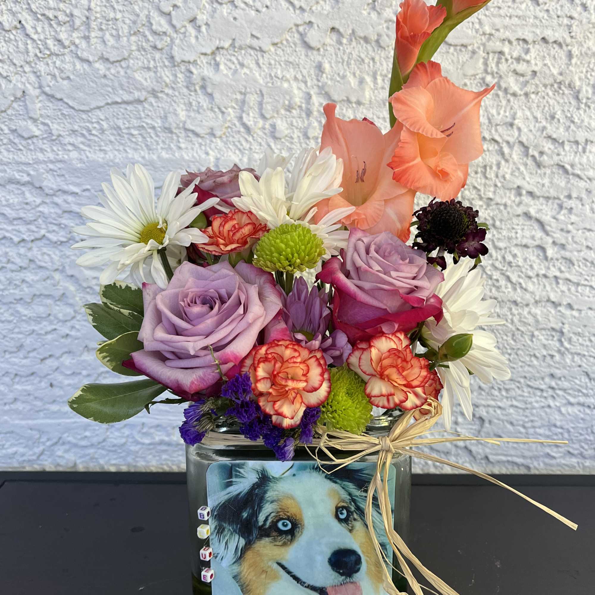 Mixed bouquet in a glass vase with a dog photo on the front