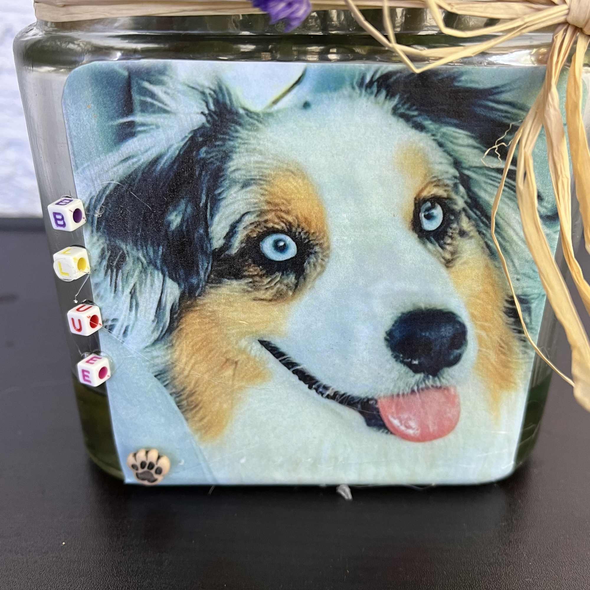 Decorative glass jar with a dog face print and raffia bow