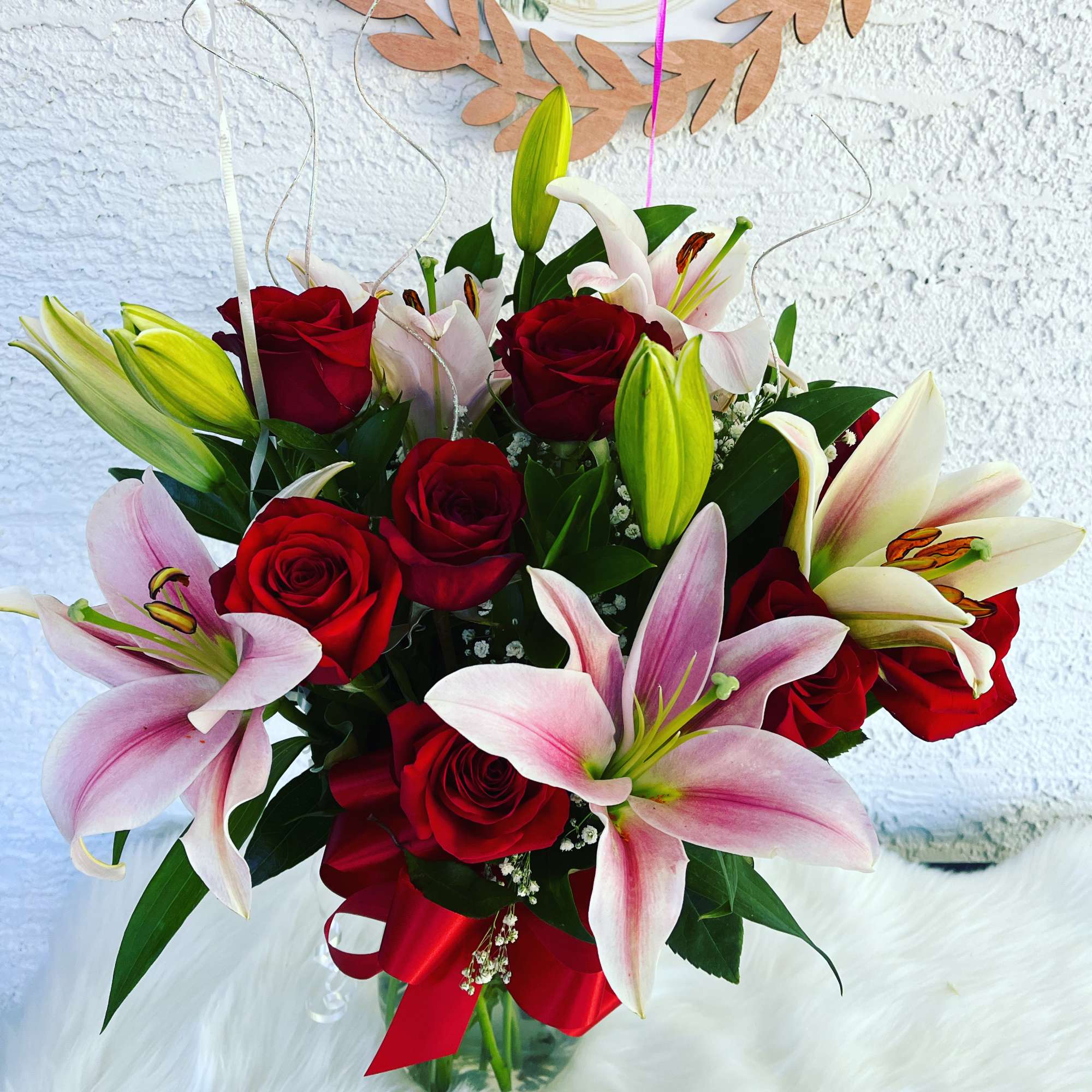 Bouquet of red roses and pink lilies with a red ribbon