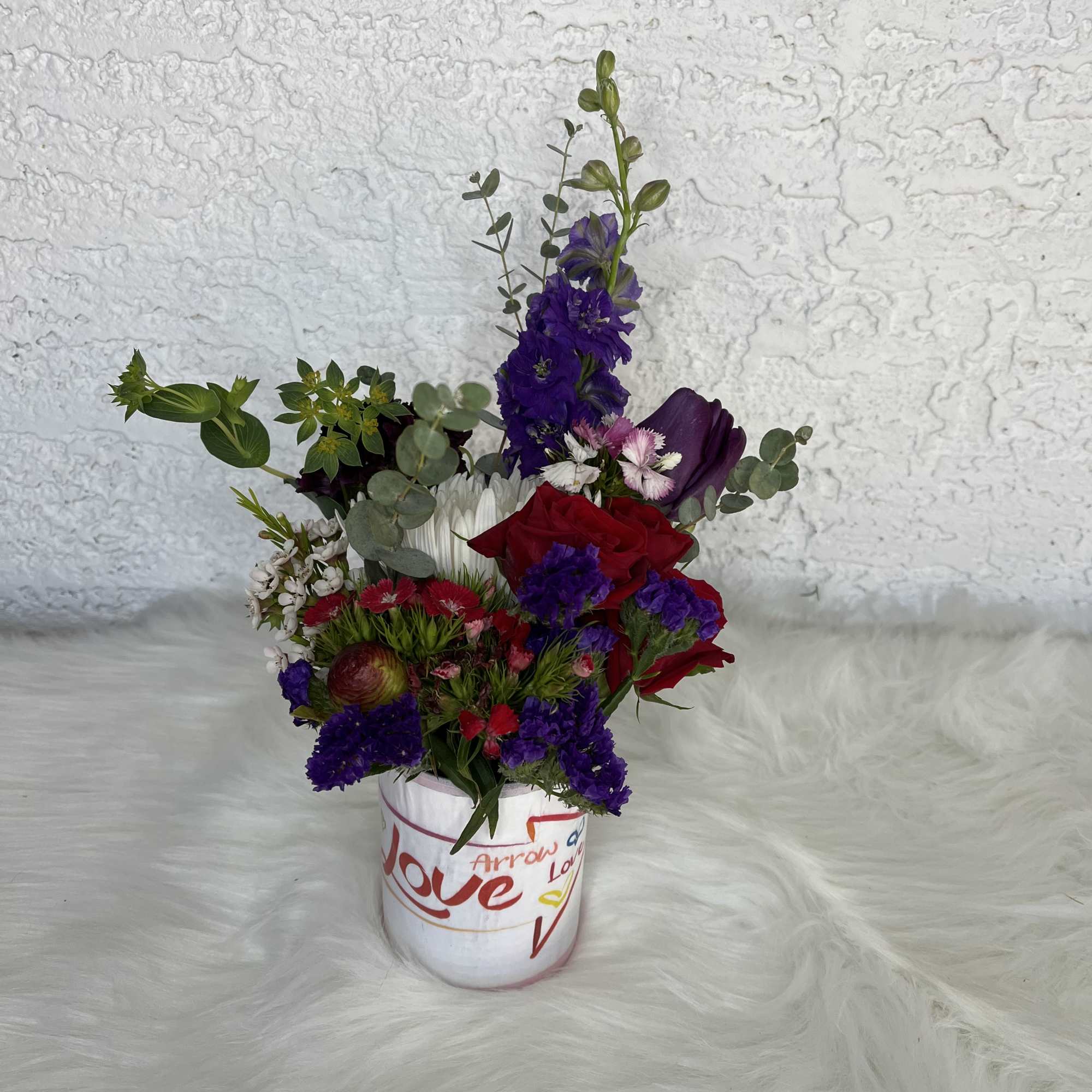 Mixed bouquet in a white vase with red and purple flowers