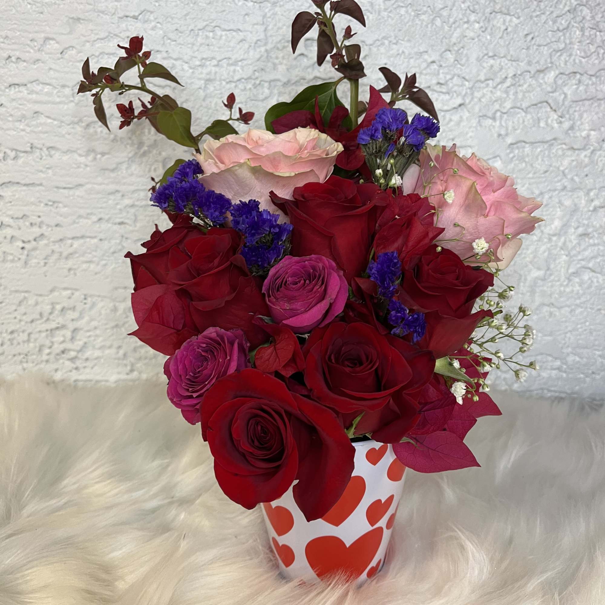 Bouquet of red and pink roses in a heart-patterned cup