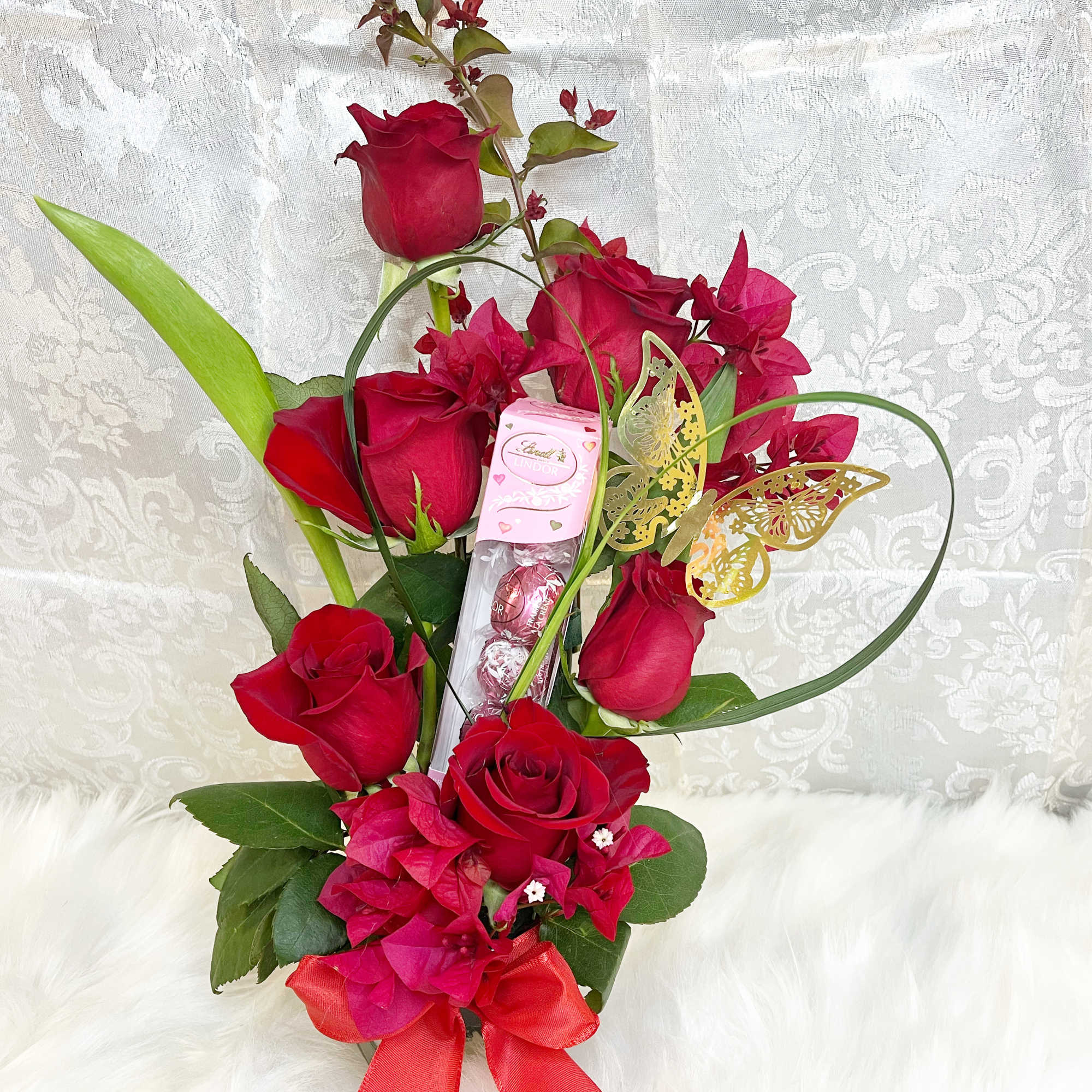 Red roses with pink flowers and a candy box, tied with a red ribbon