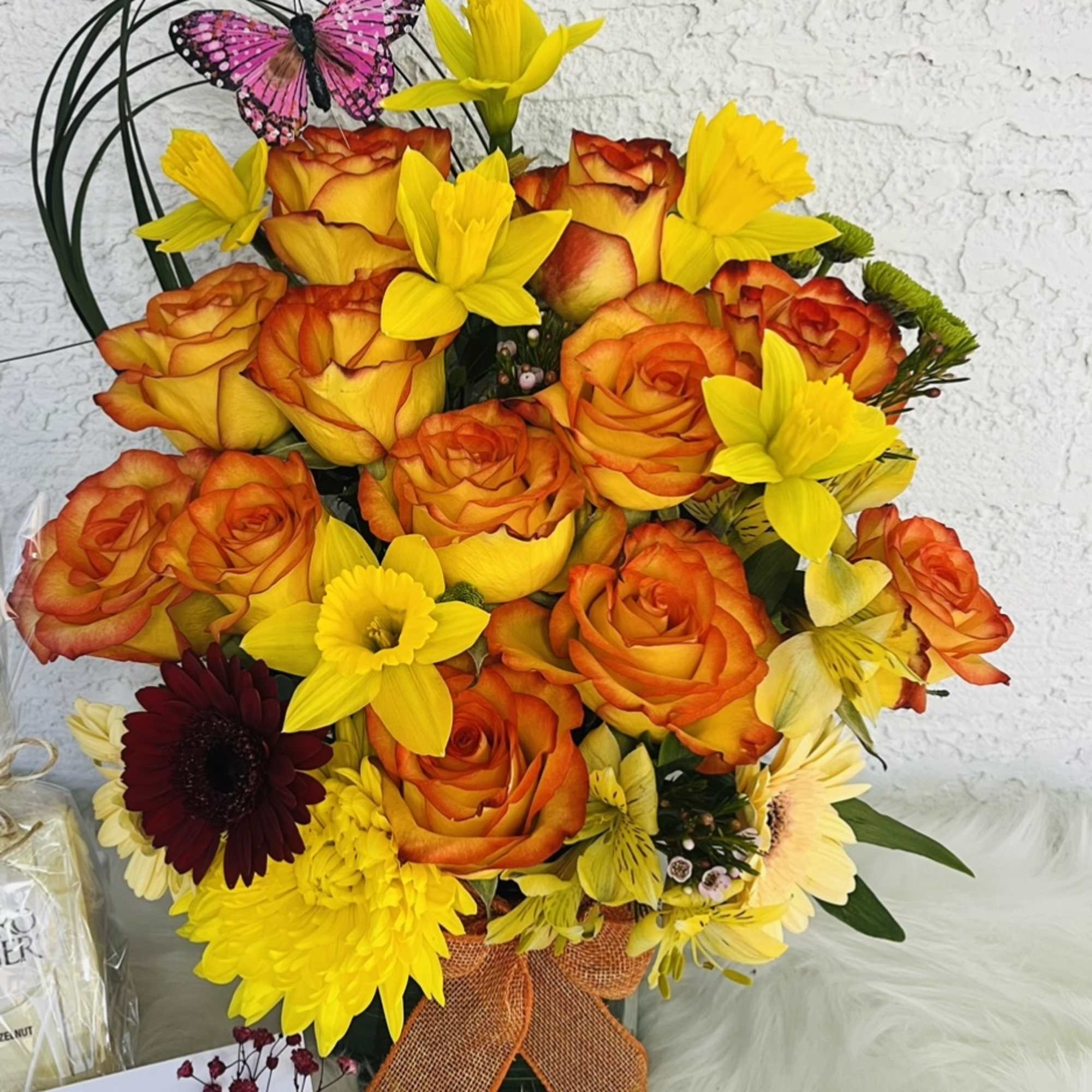 Bouquet of orange roses and yellow flowers with a pink butterfly decoration