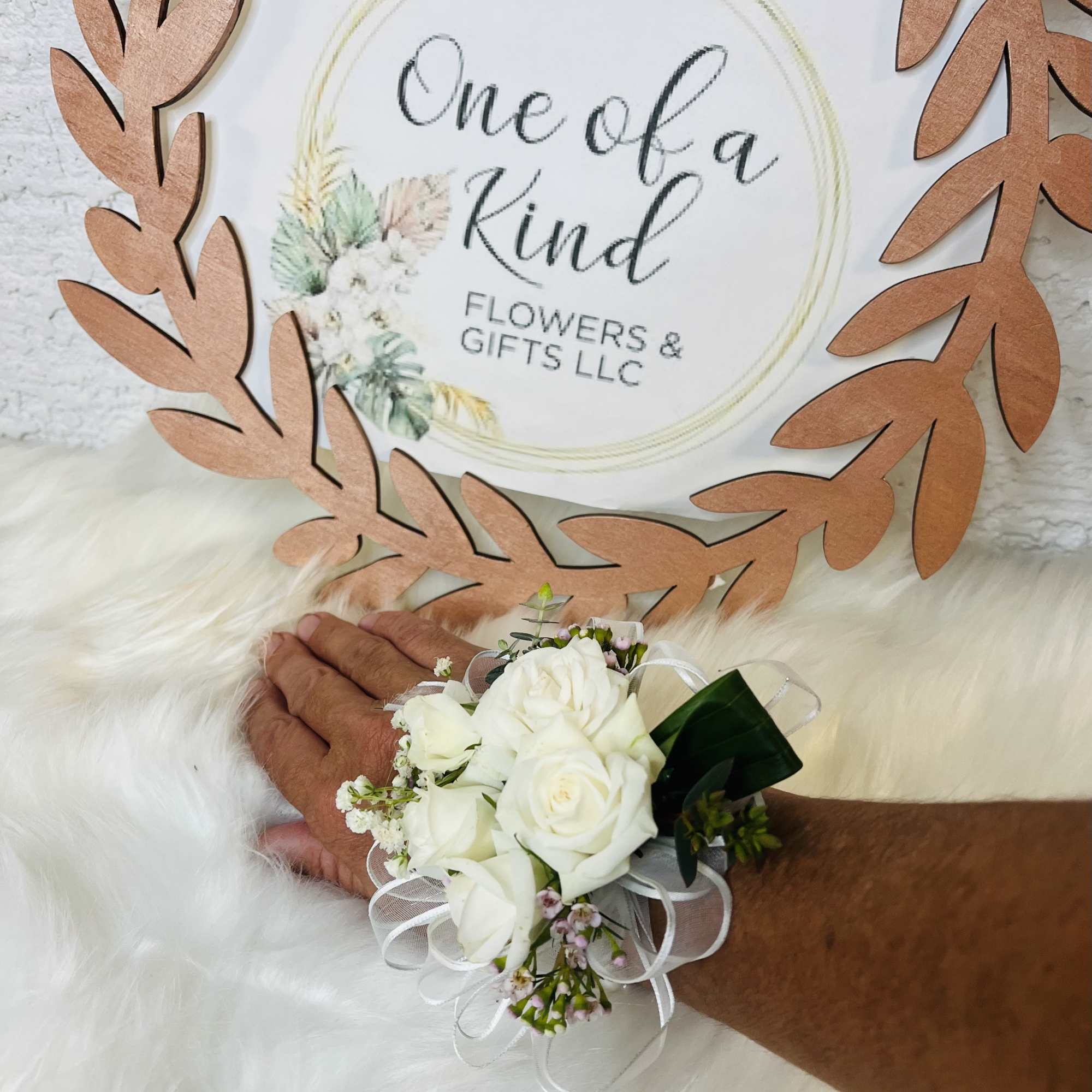 White rose wrist corsage with ribbon on a person's wrist