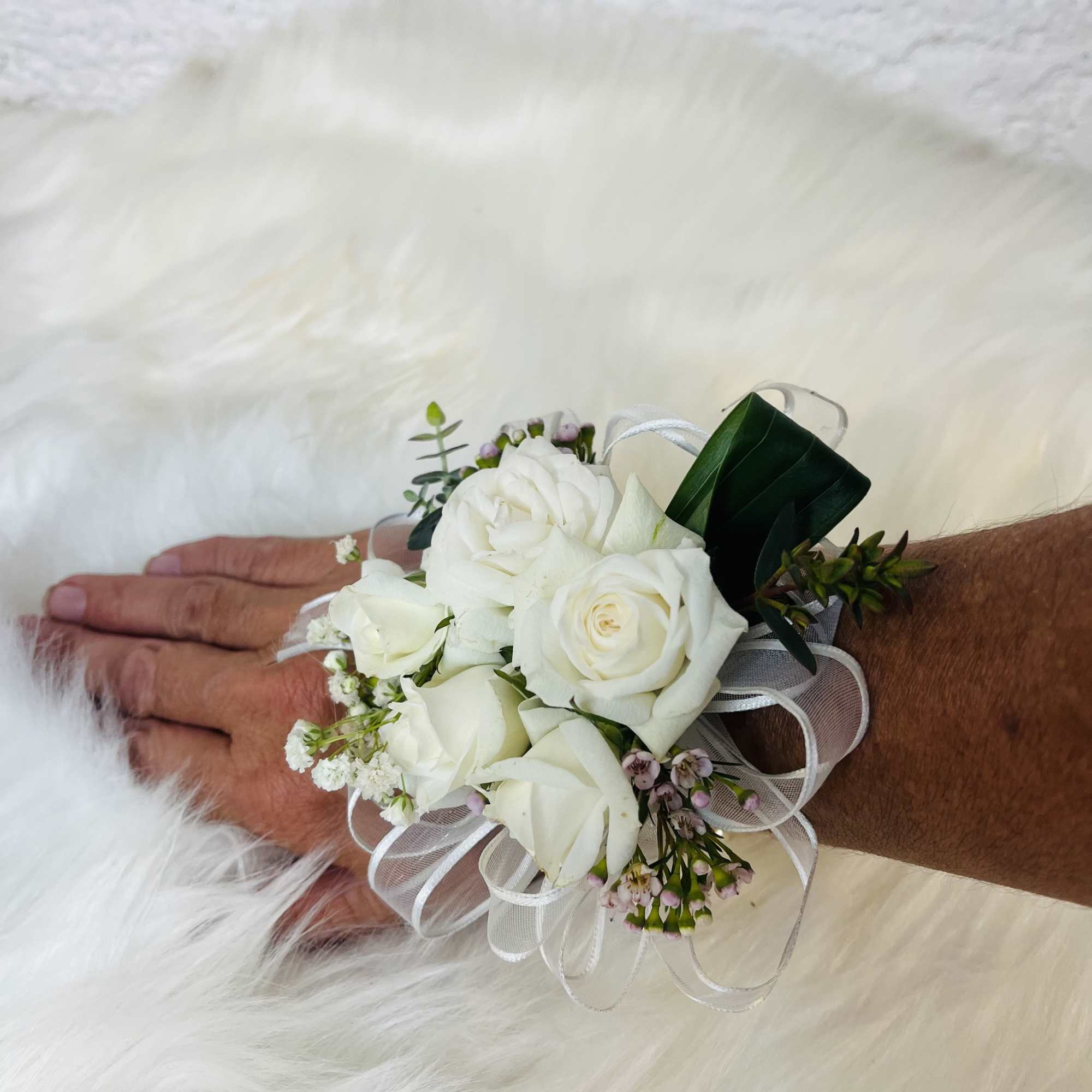 White rose wrist corsage with ribbon and small pink filler flowers