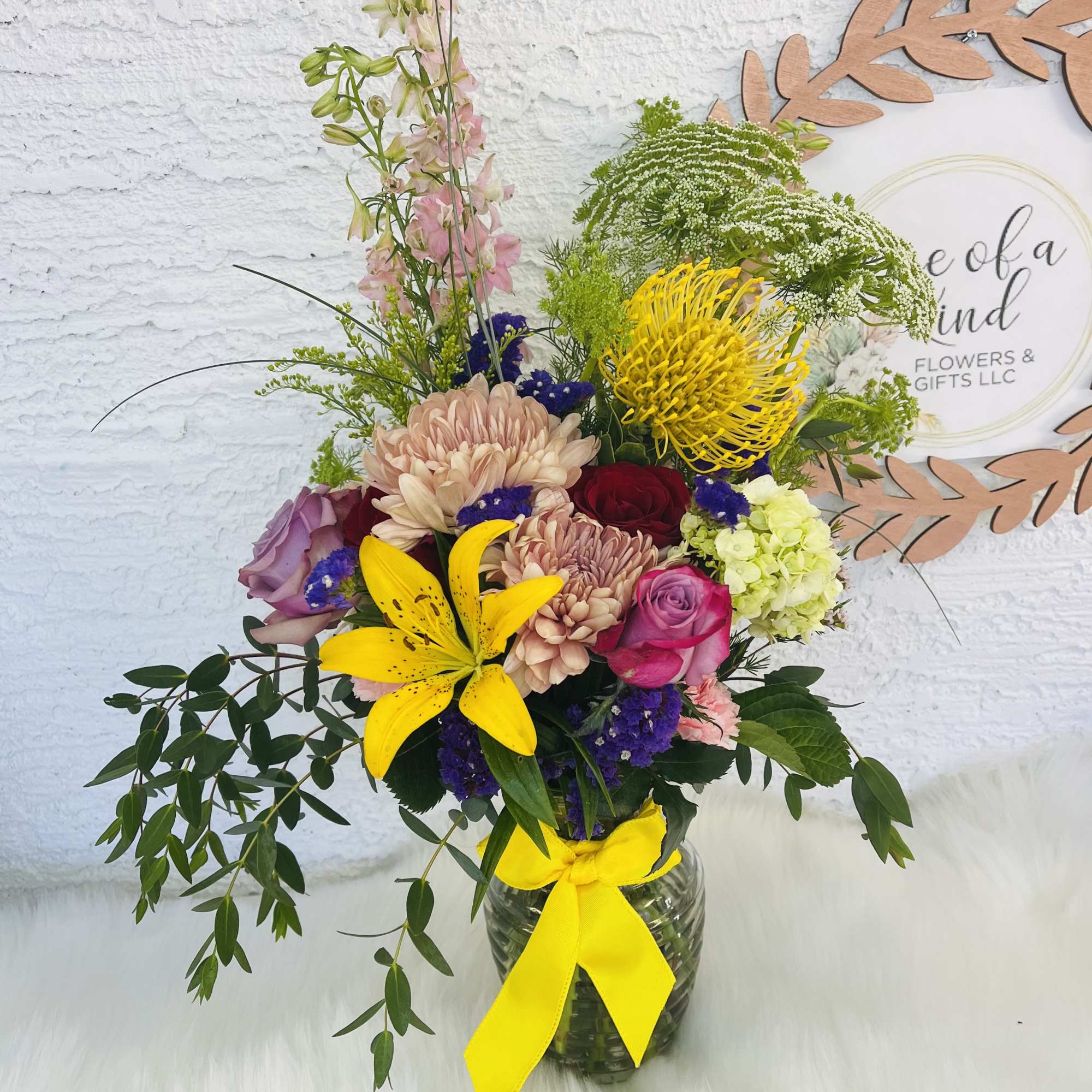 Mixed bouquet in a glass vase with a yellow ribbon