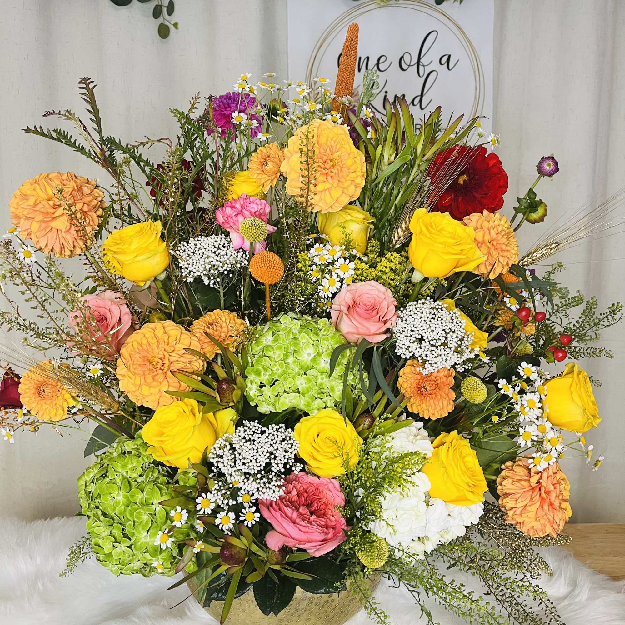Colorful mixed flower arrangement in a gold bowl vase