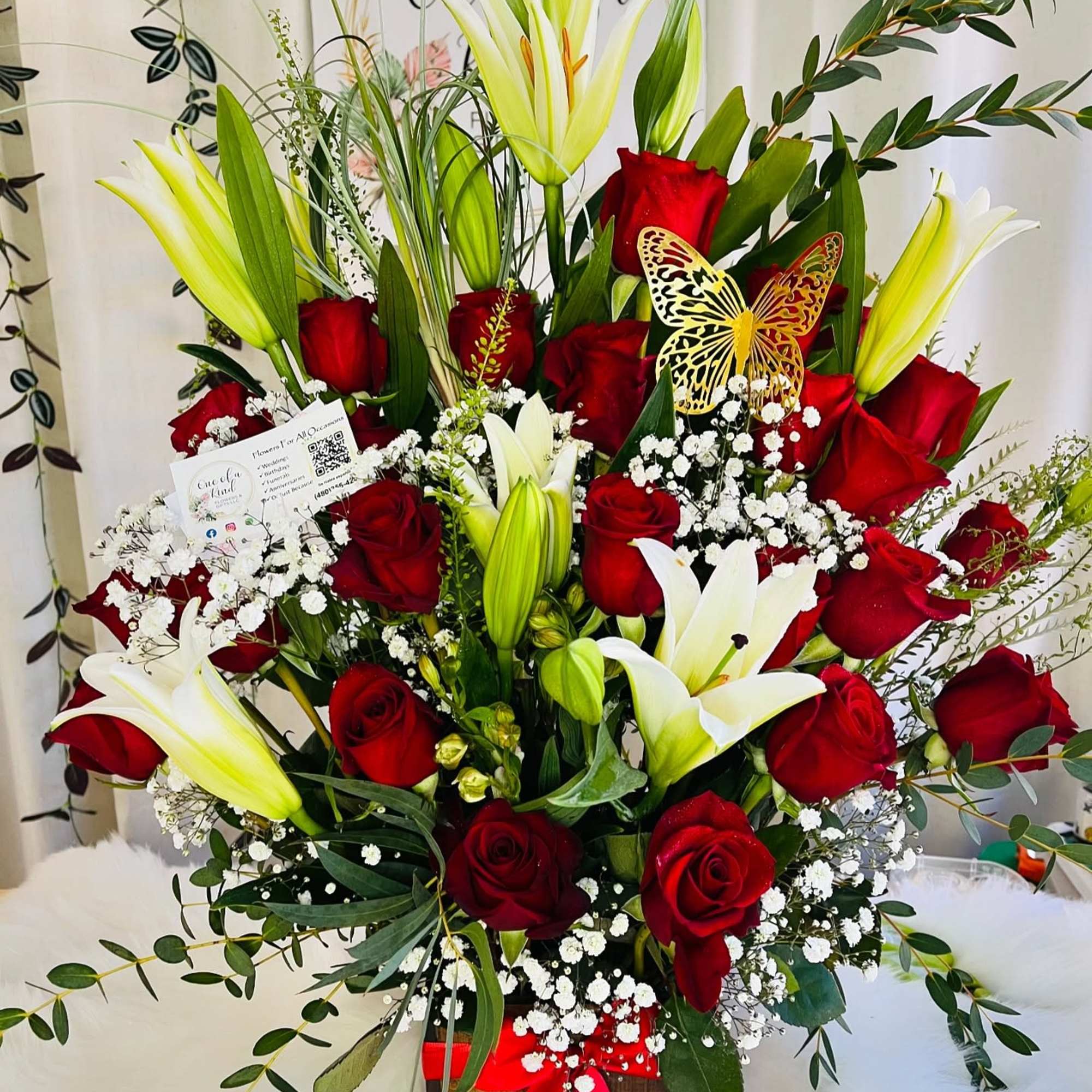 Red roses and white lilies in a basket with baby's breath