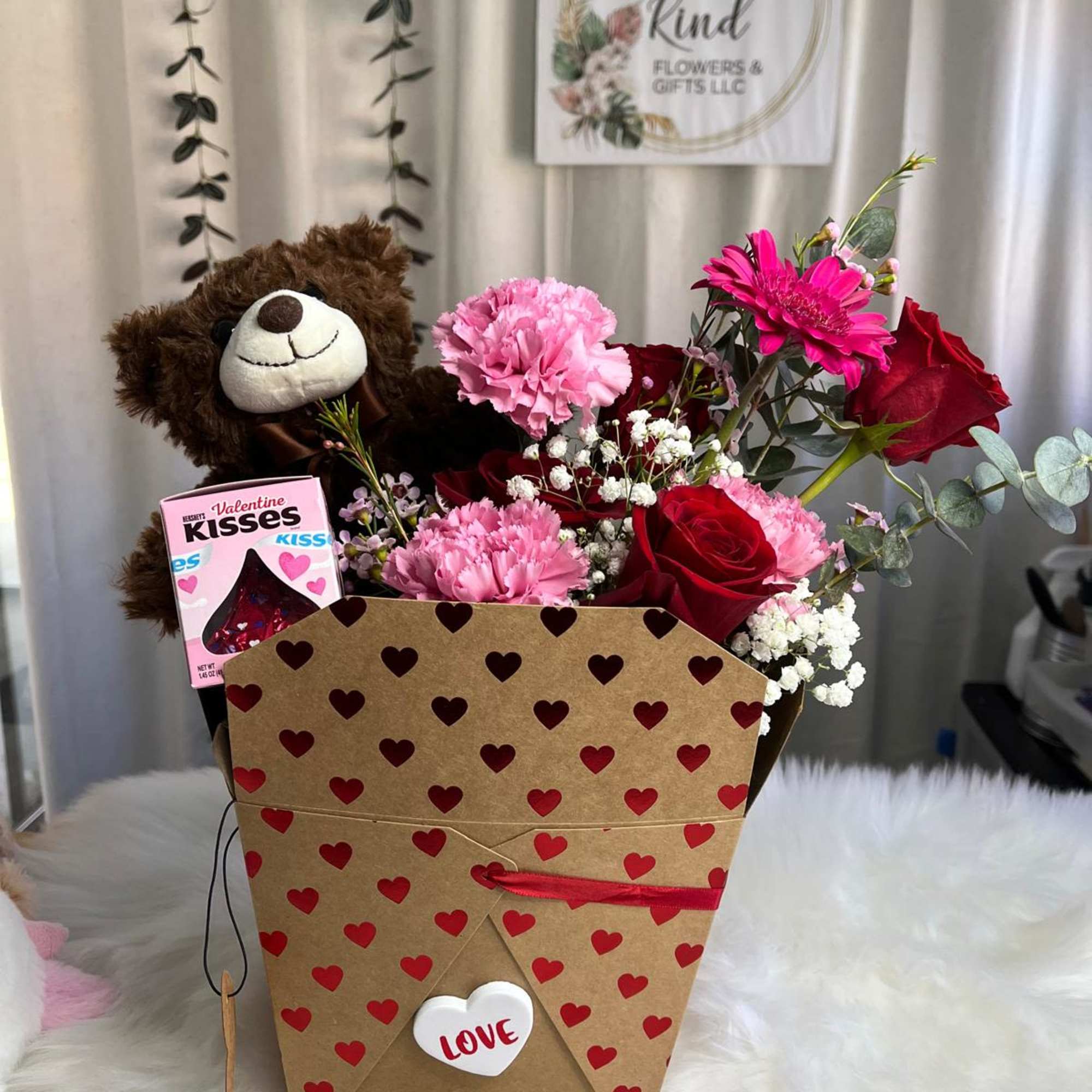 Heart-pattern gift box with a teddy bear, chocolates, and pink and red flowers