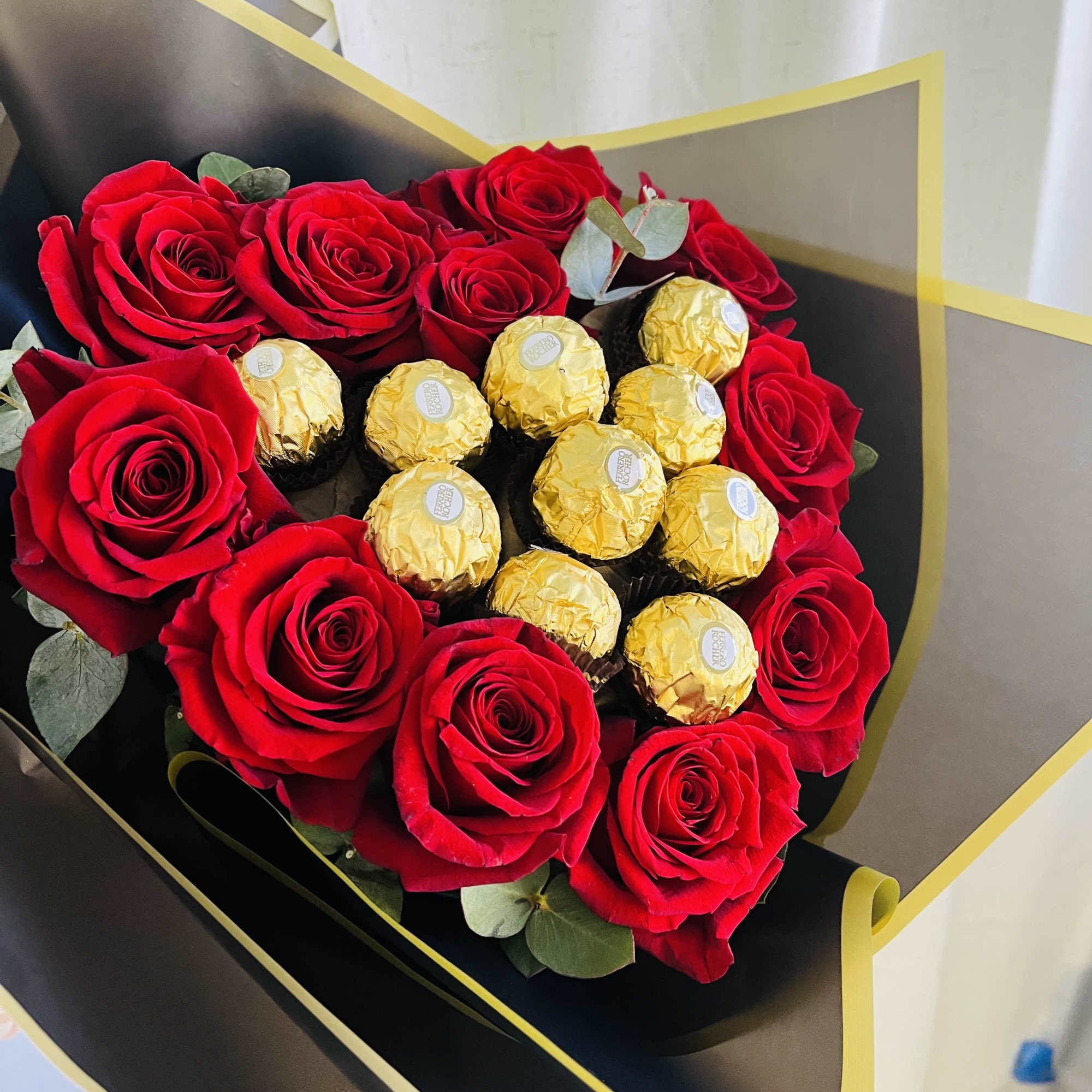 Bouquet of red roses with gold-wrapped chocolates