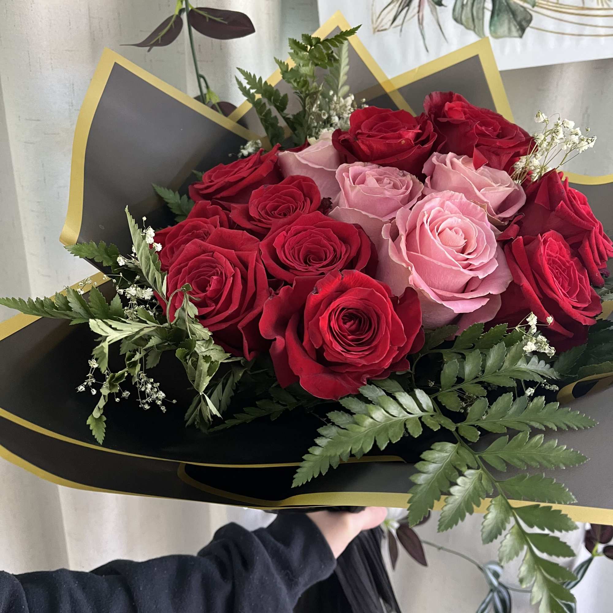 Bouquet of red and pink roses wrapped in black paper with gold trim, photo 3 of 3