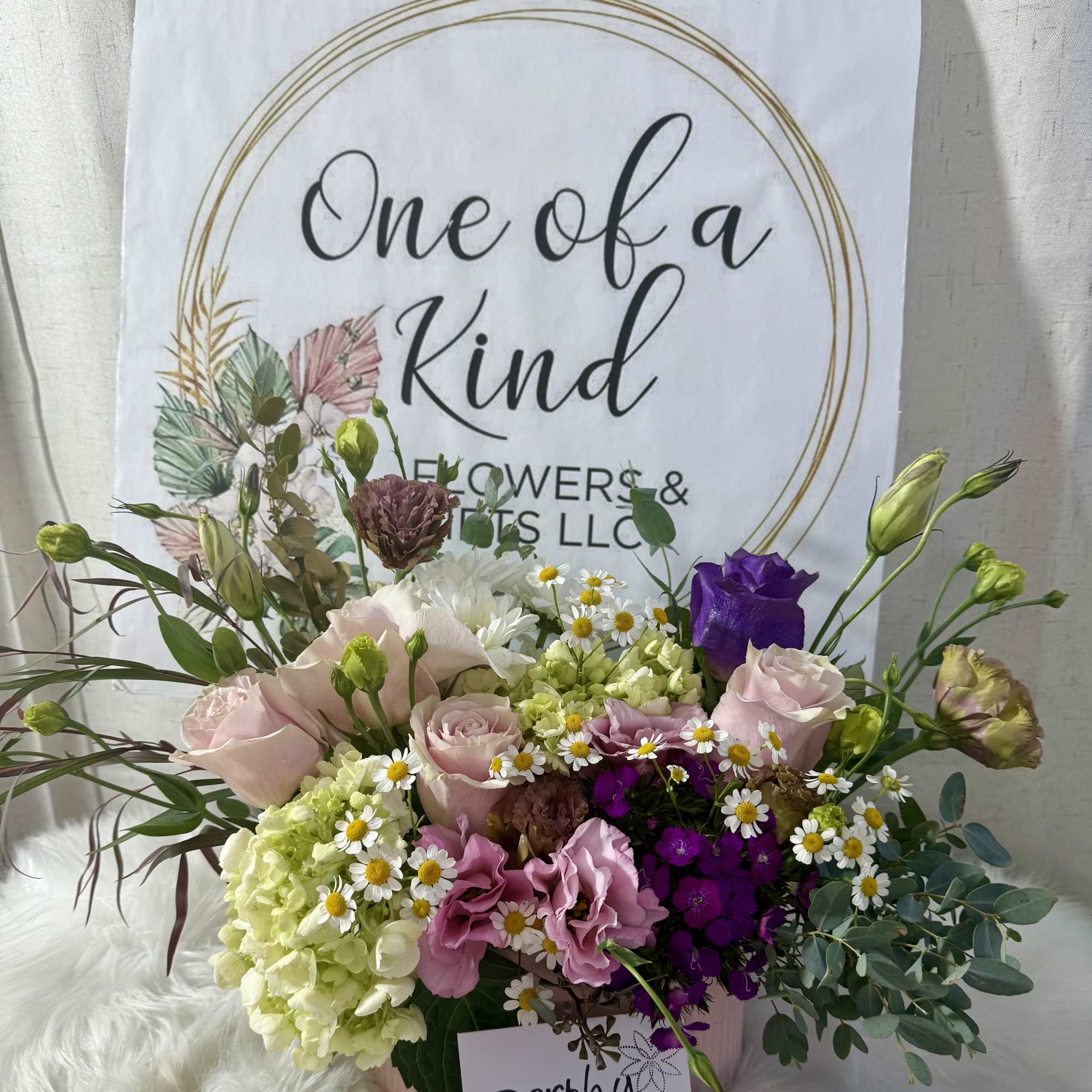 Mixed bouquet of pink, purple, white, and green flowers in a container, photo 3 of 3