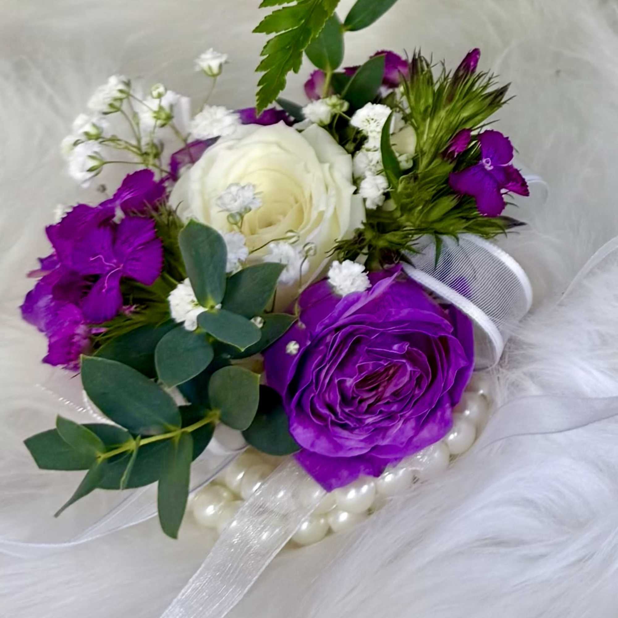 Purple and white rose bouquet with ribbon and pearl accents