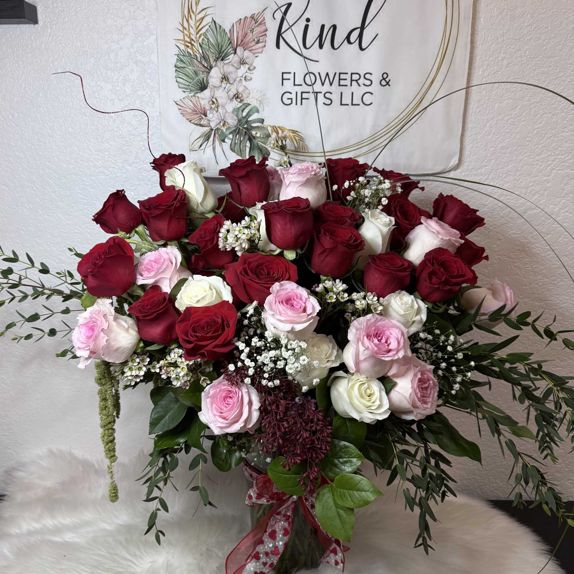 Large bouquet of red, pink, and white roses with baby's breath
