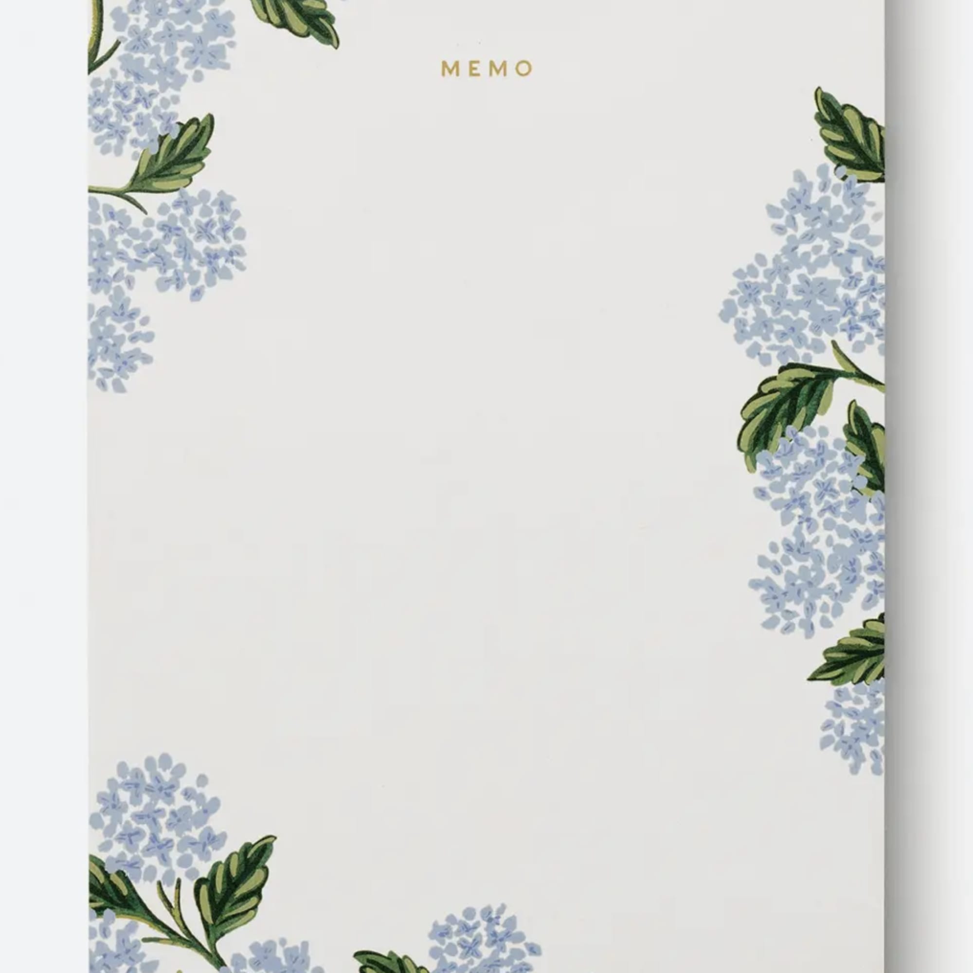 Floral memo pad with pale blue blossoms and green leaves around the border