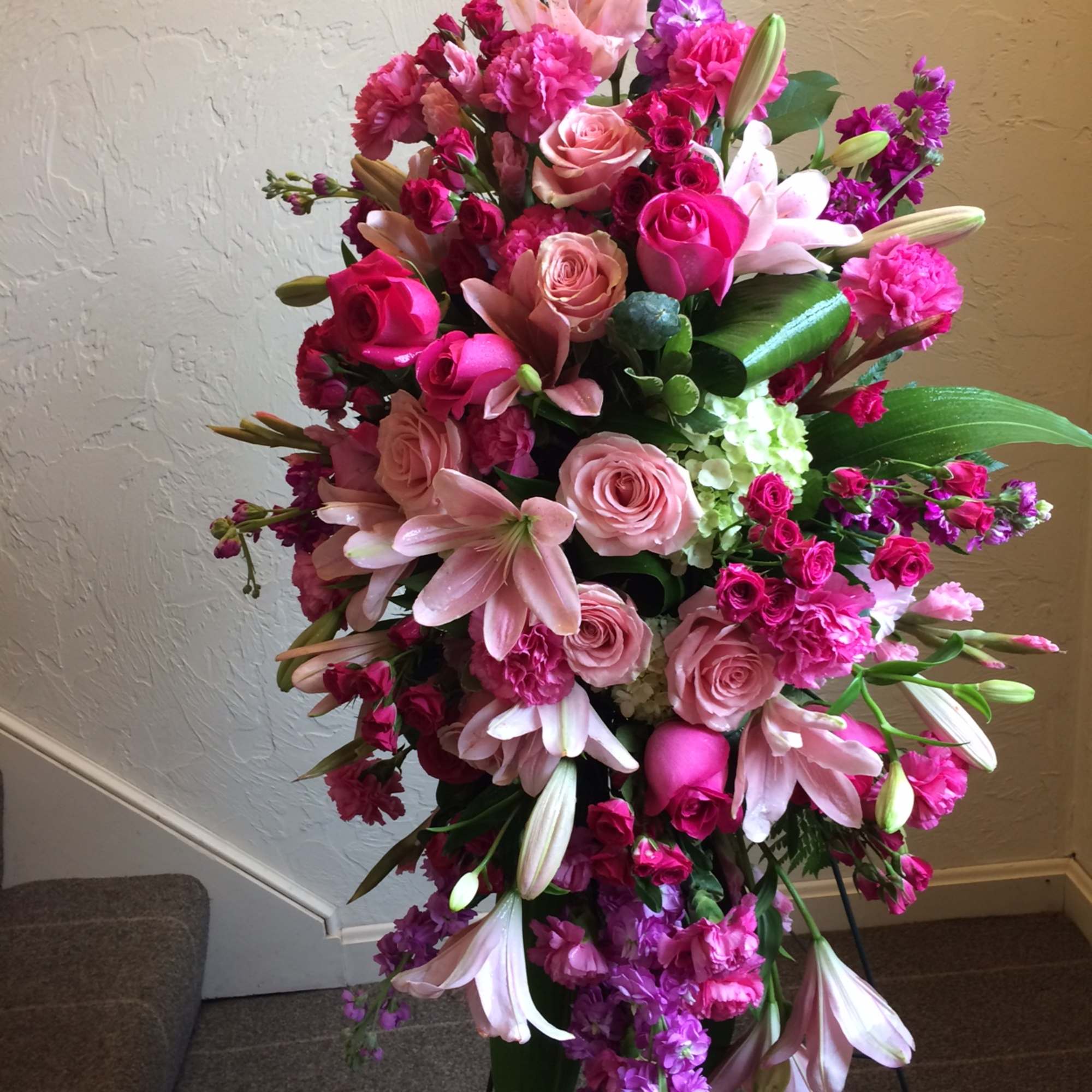 Large pink and purple floral standing arrangement with roses and lilies