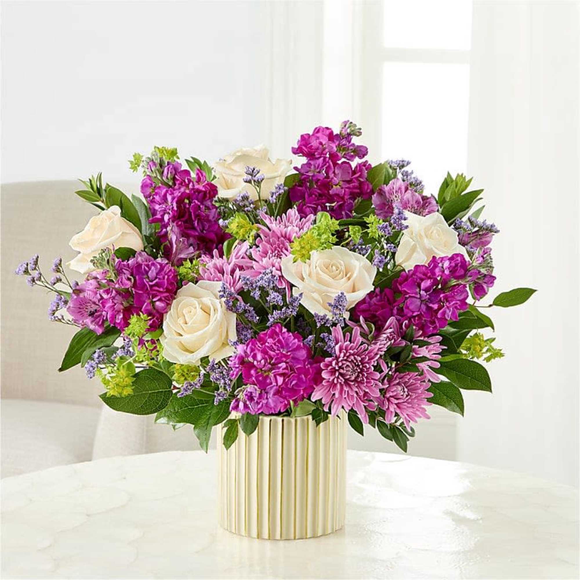 Creamy white roses set against vivid purple stock-like blooms and soft pink