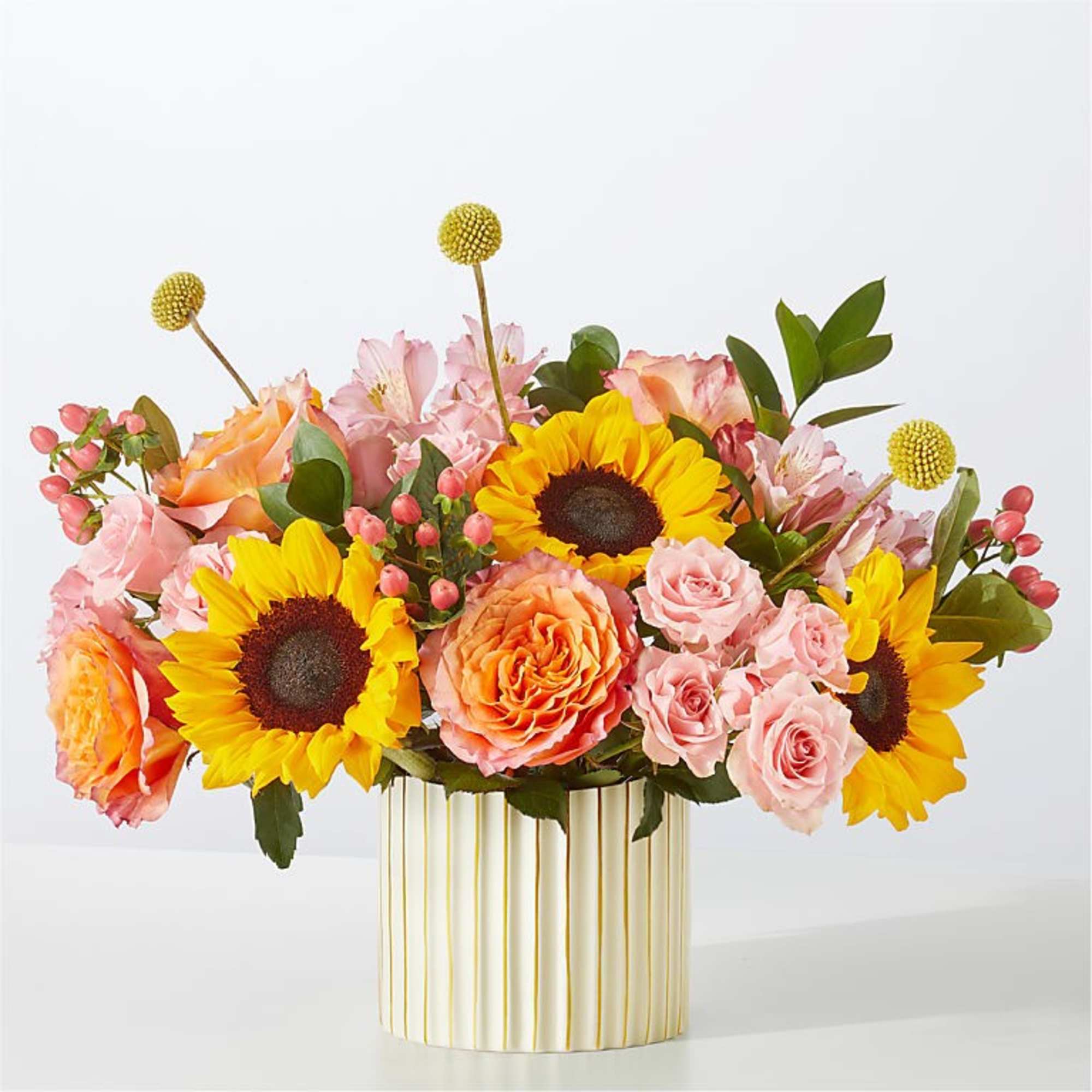 Pink and orange bouquet with sunflowers in a striped vase