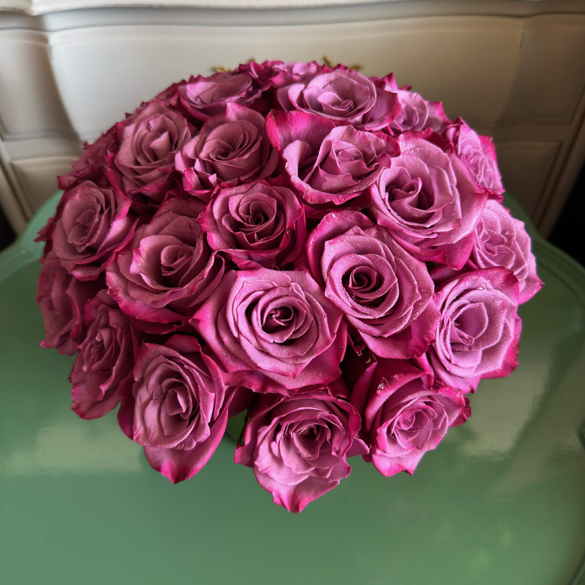 Round bouquet of pink roses on a green chair