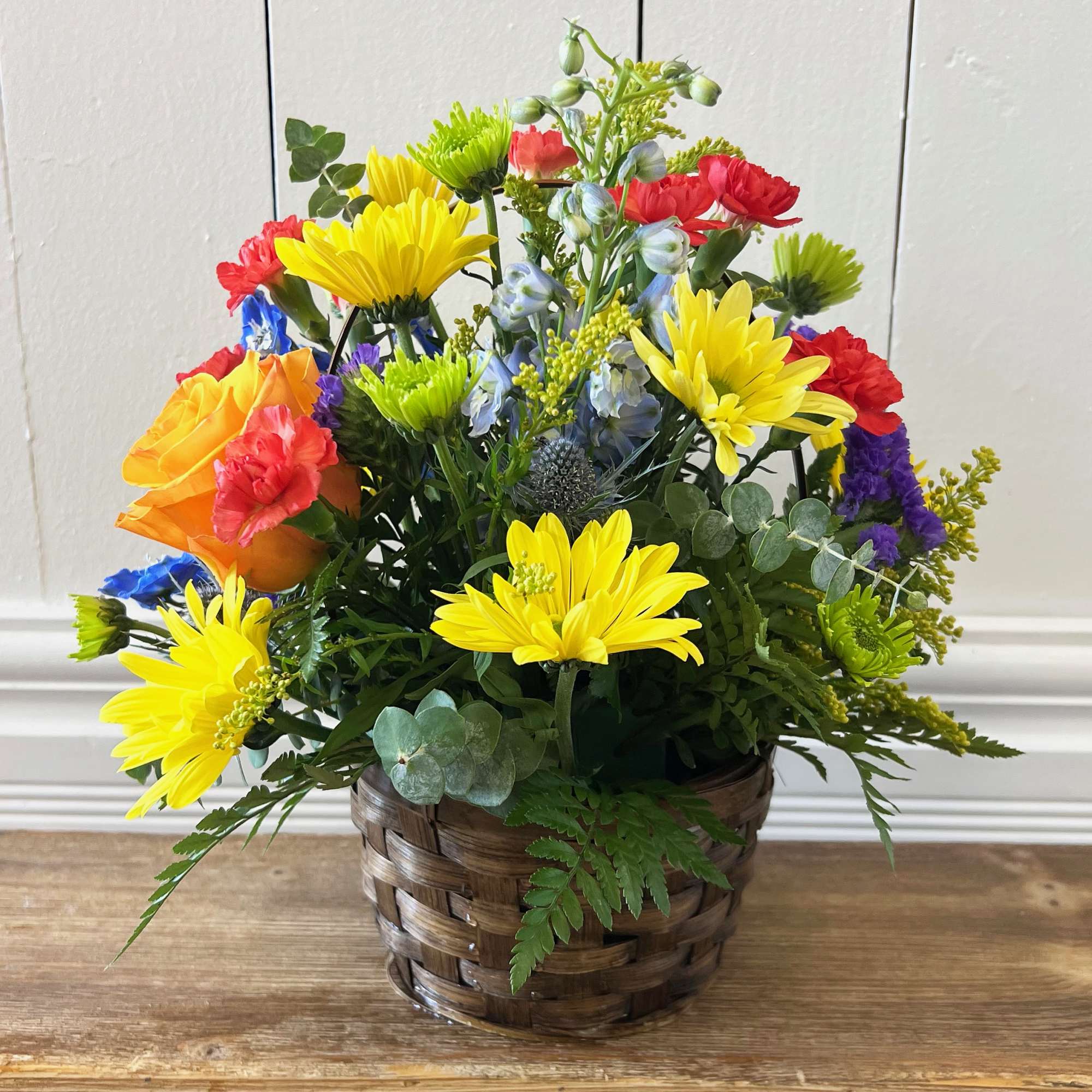 Colorful mixed flower arrangement in a woven basket