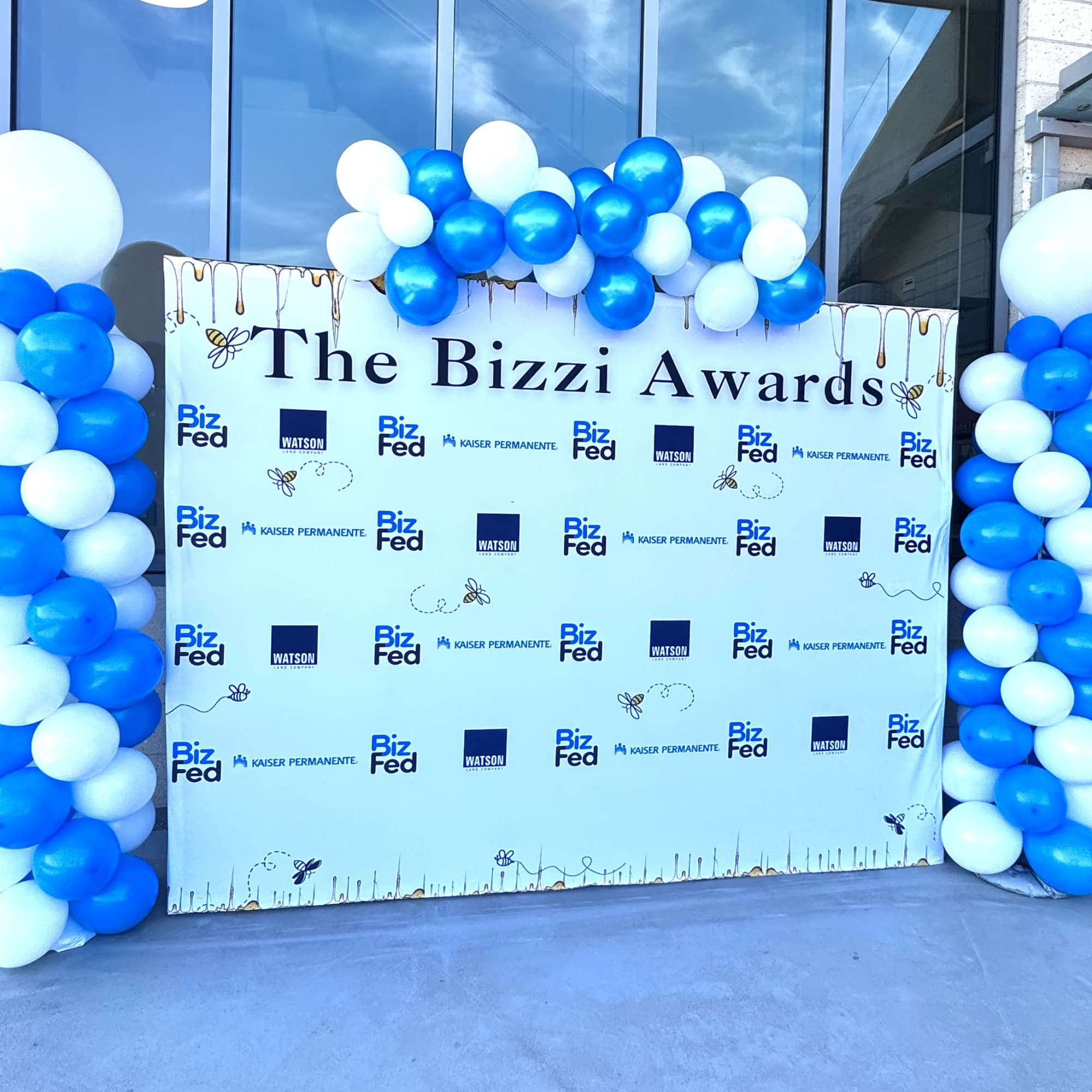 Blue and white balloon columns framing an awards backdrop