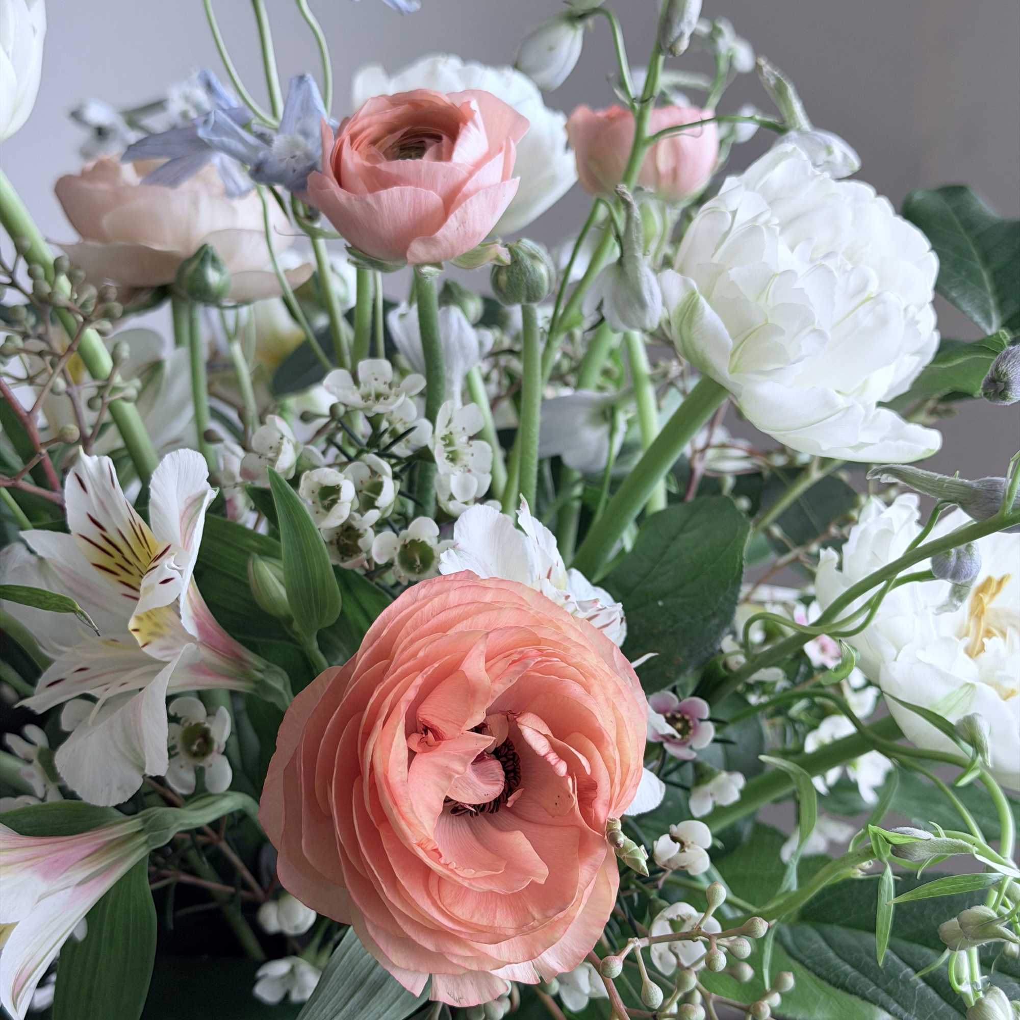 Bouquet of peach and white flowers with green foliage