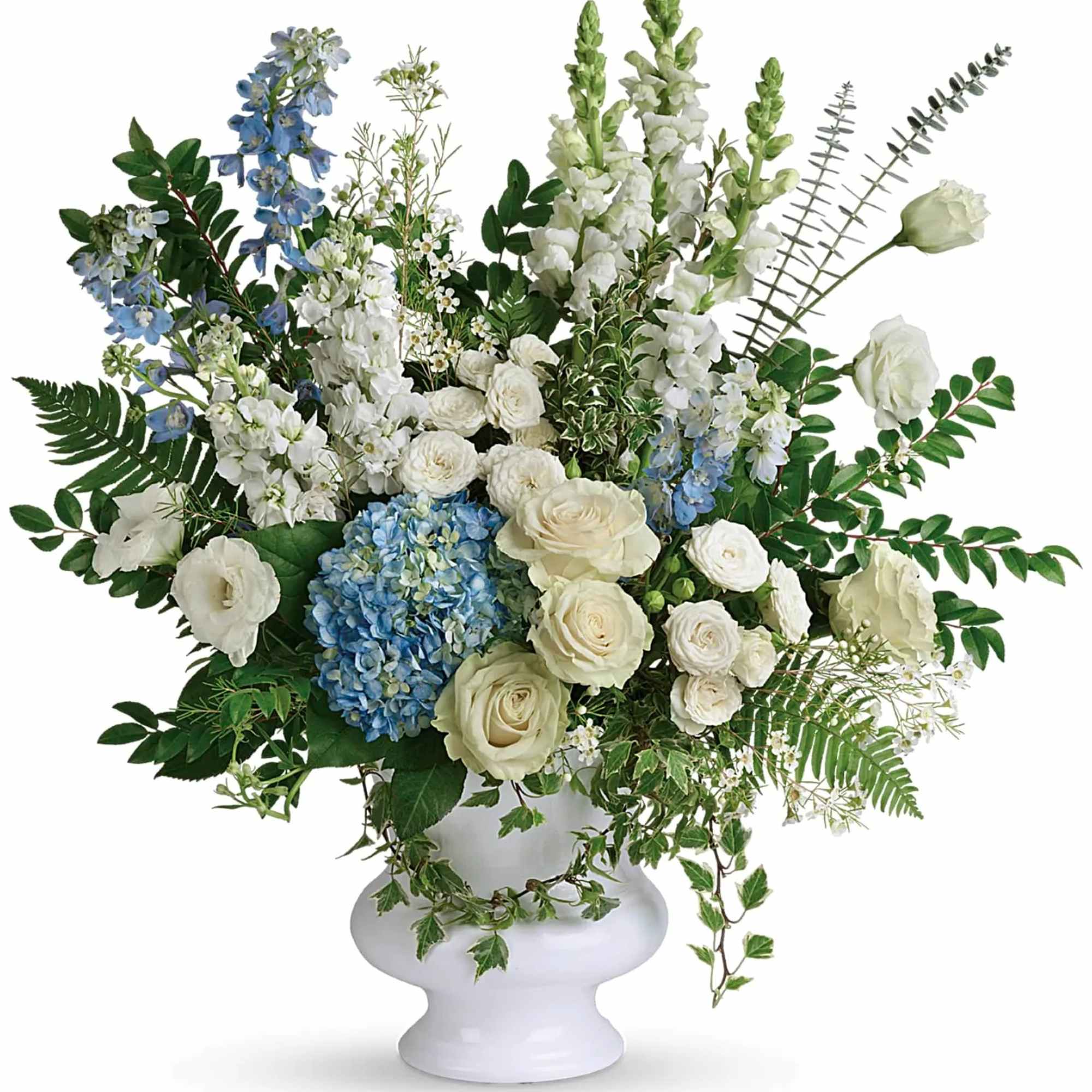 White and blue floral arrangement in a white pedestal vase